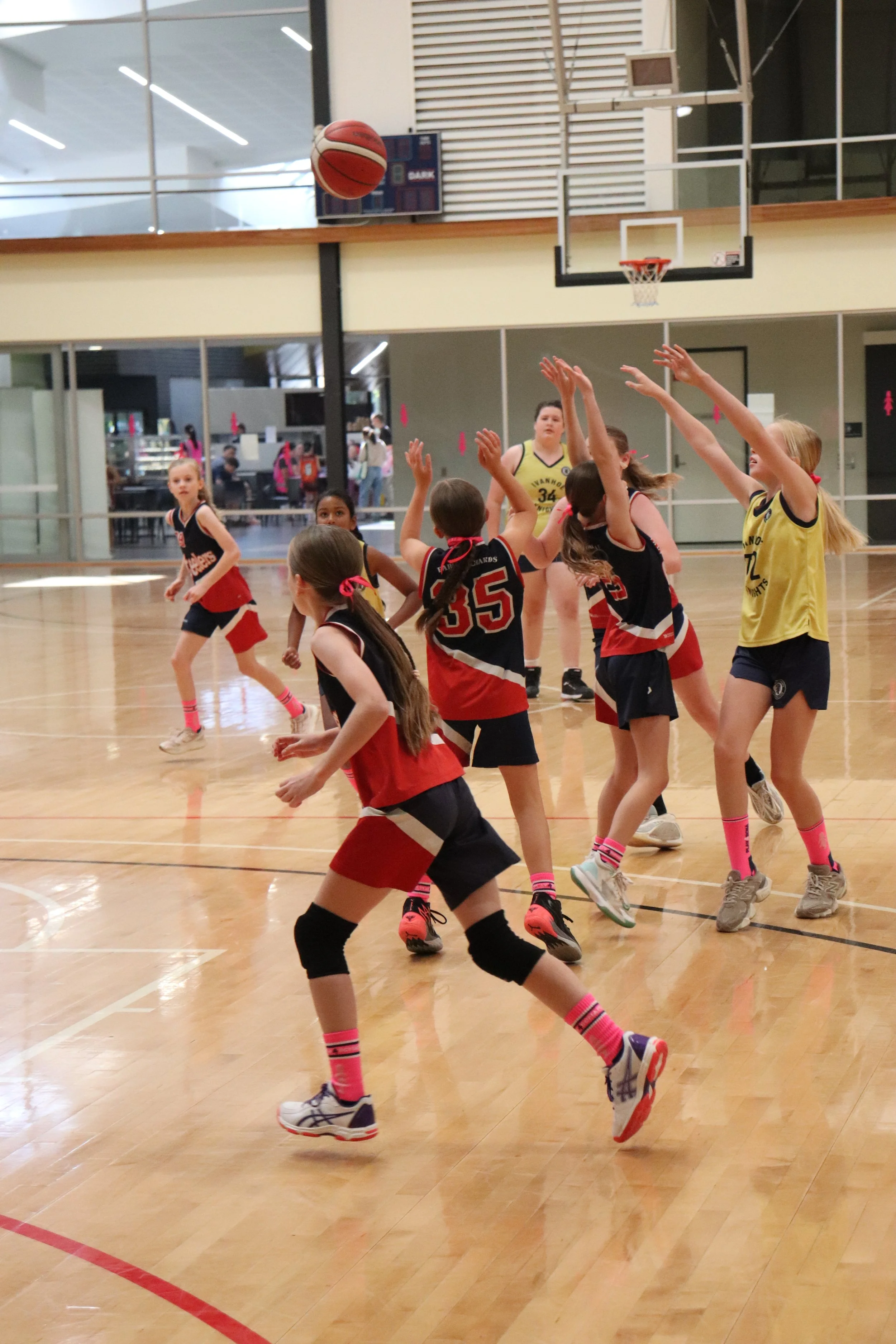 Junior girls basketball players smiling playing basketball EDJBA.