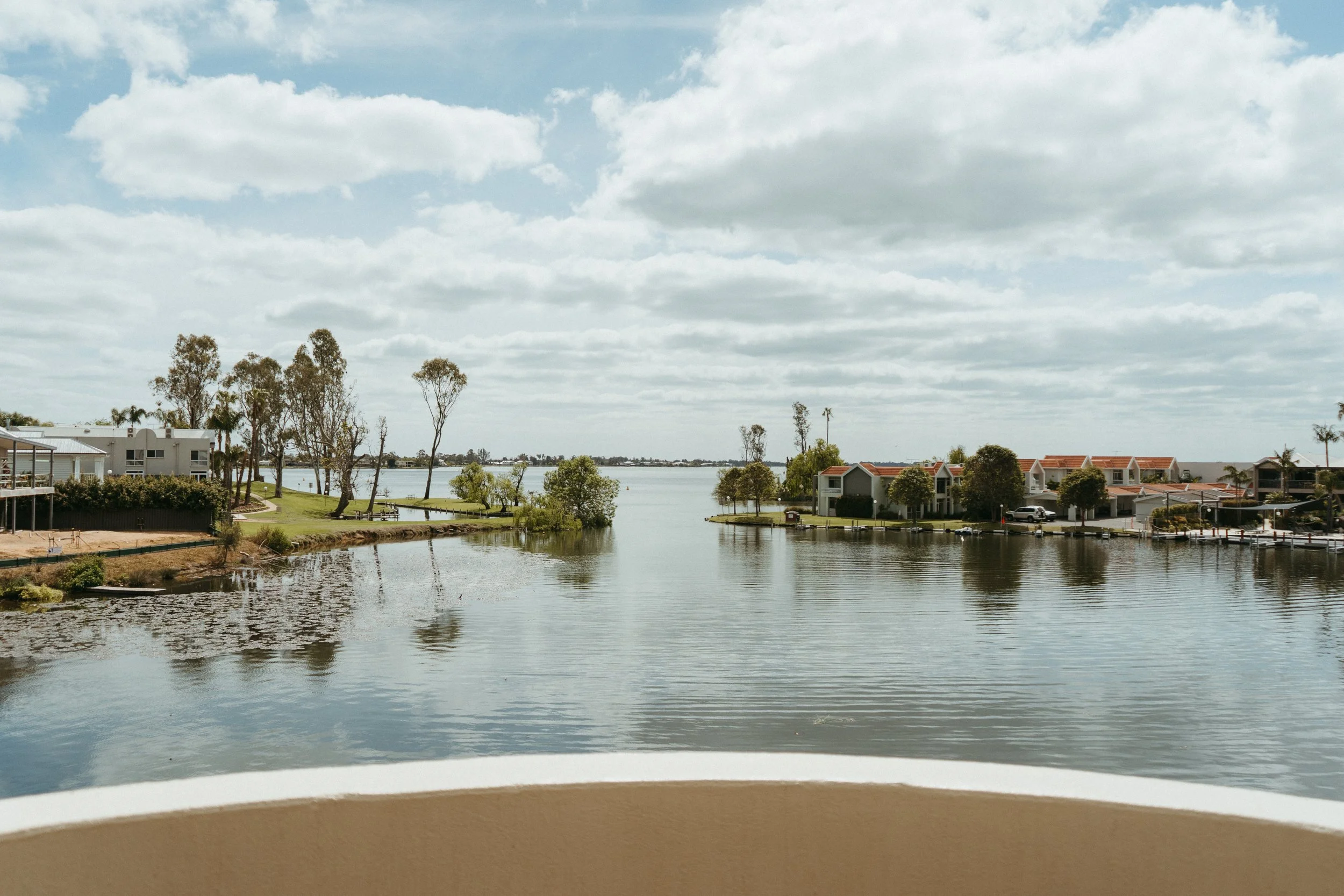 Lake Mulwala Yarrawonga - A lake or river with houses and trees along the shore, under a partly cloudy sky.