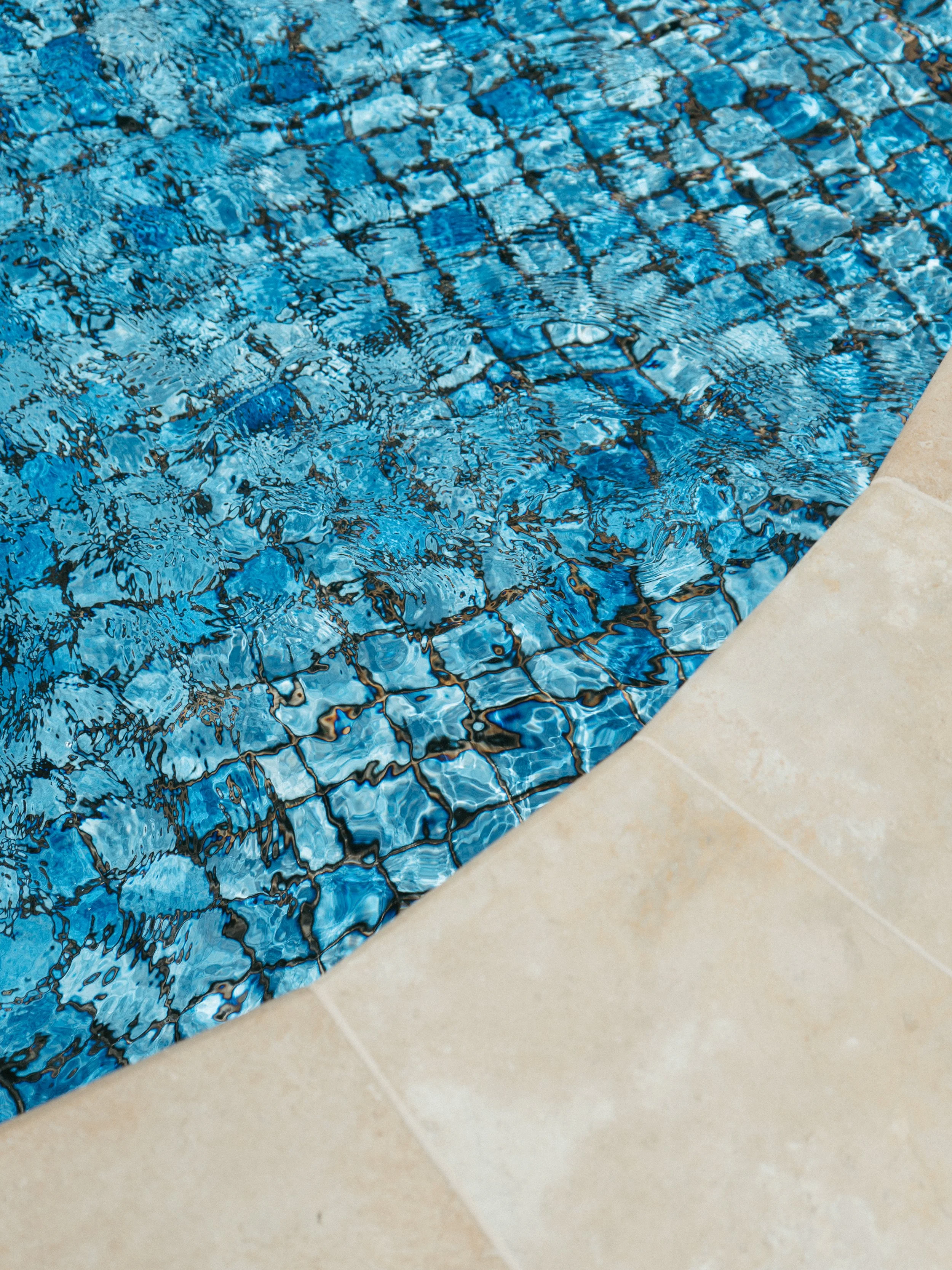 Lake Mulwala Yarrawonga - Close-up of the edge of a swimming pool with blue tiled floor and beige poolside tiles.