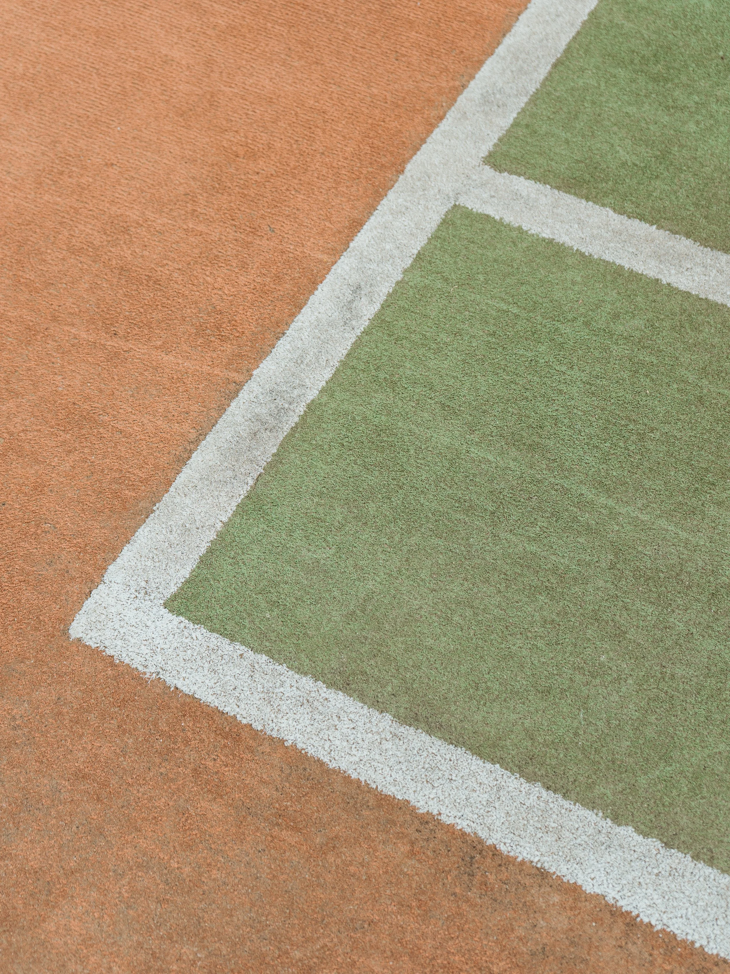 Lake Mulwala Yarrawonga - Close-up of a section of a tennis court with green and orange surfaces separated by white boundary lines.