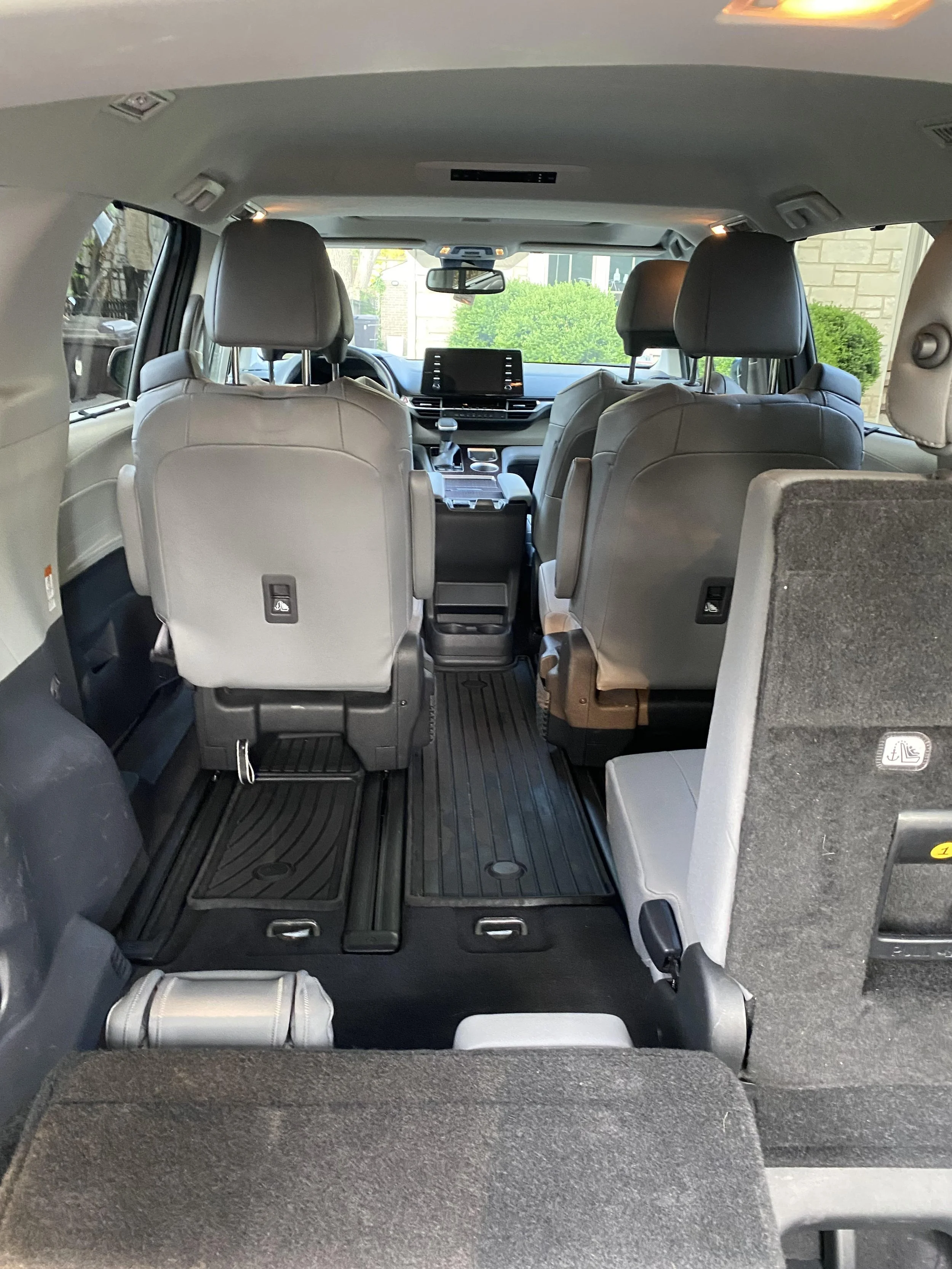 Interior view of a minivan with folded rear seats and visible front seats, dashboard, and center console, providing a spacious cargo area.