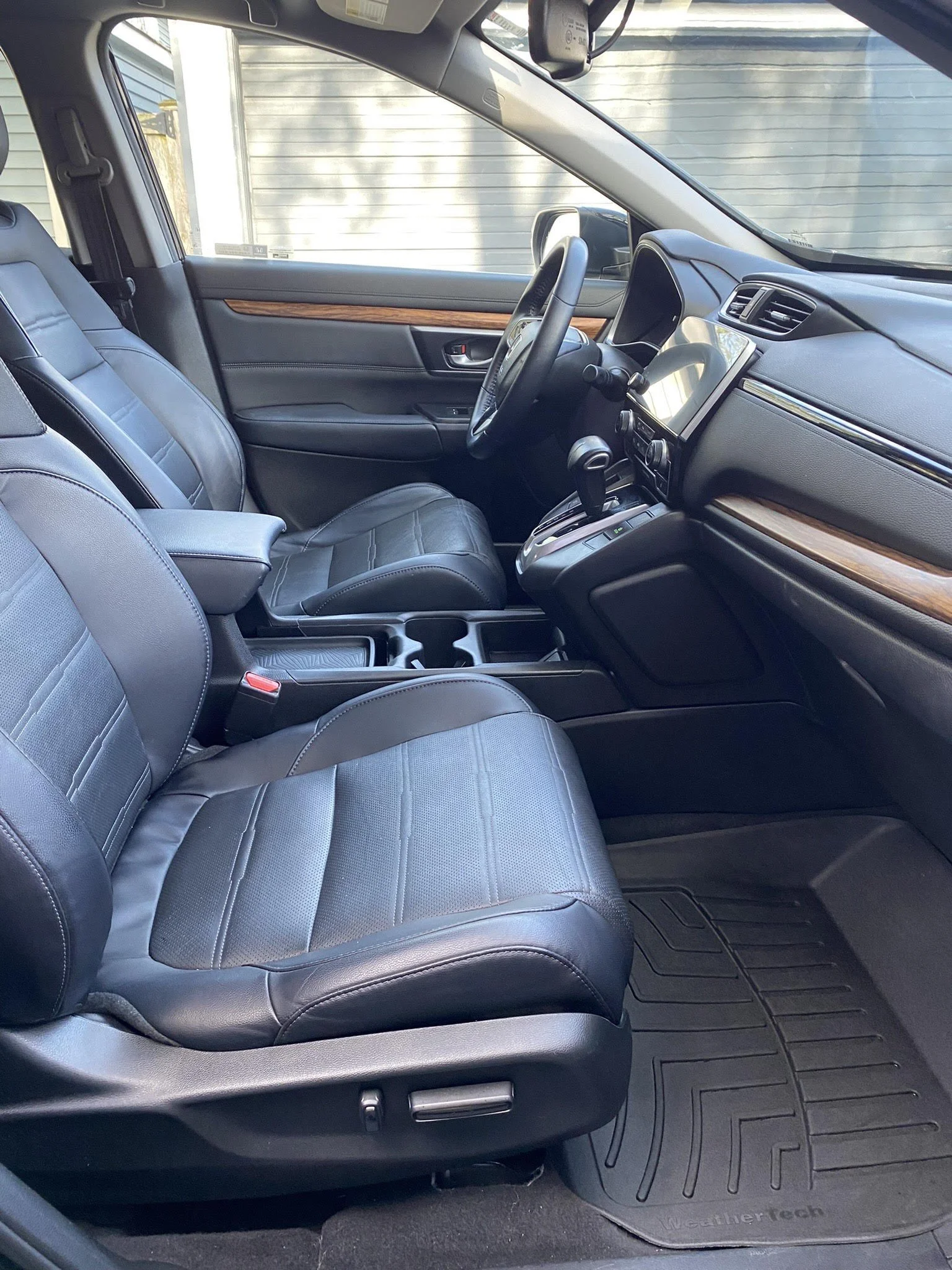 Interior of a car showing the front seats, dashboard, steering wheel, and floor mats.