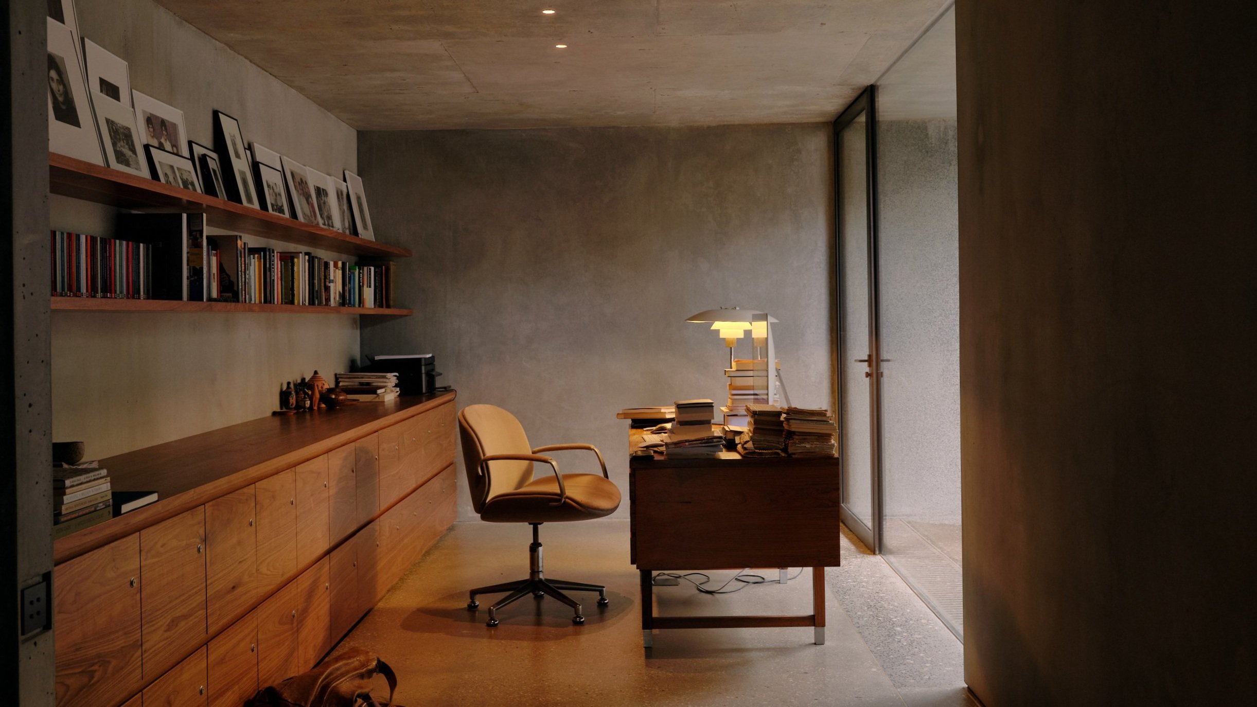 A private, modern Walnut office space looking out into the exposed raw concrete-framed light well.