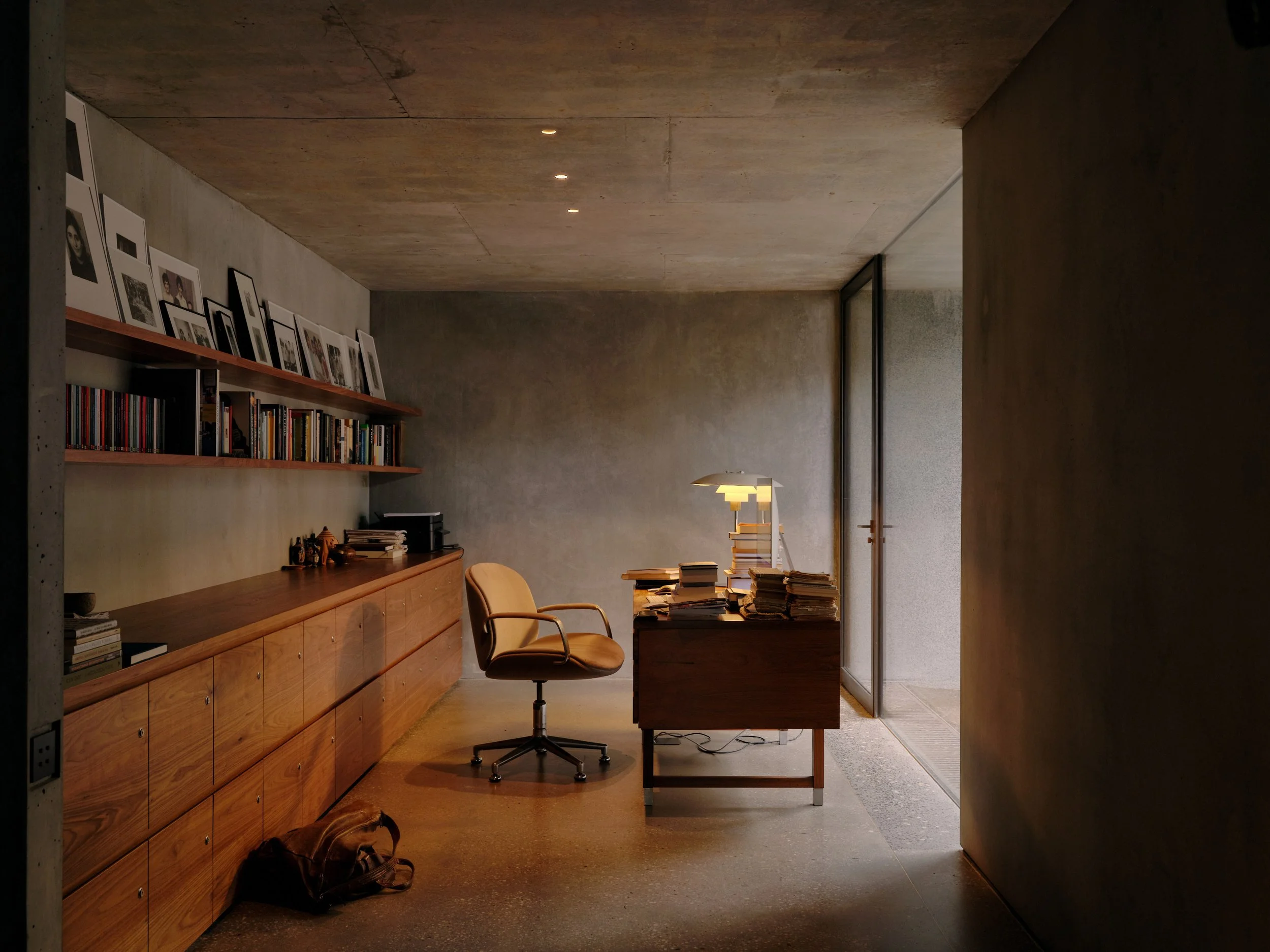 A private, modern Walnut office space looking out into the exposed raw concrete-framed light well.