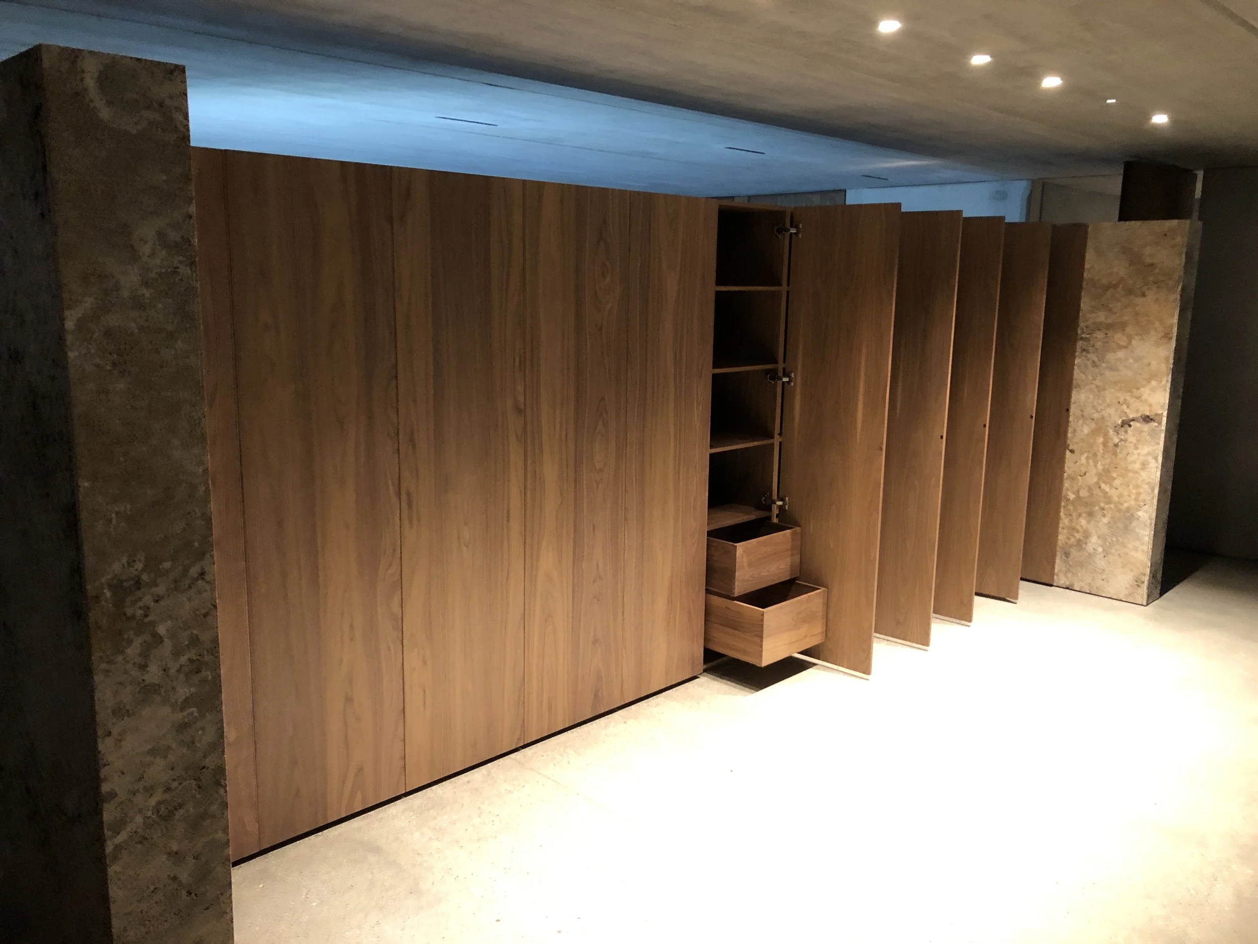 Sleek, discreet, yet ample storage tucked away behind the master bedroom. The warmth of the Walnut against the texture of the Travertine.