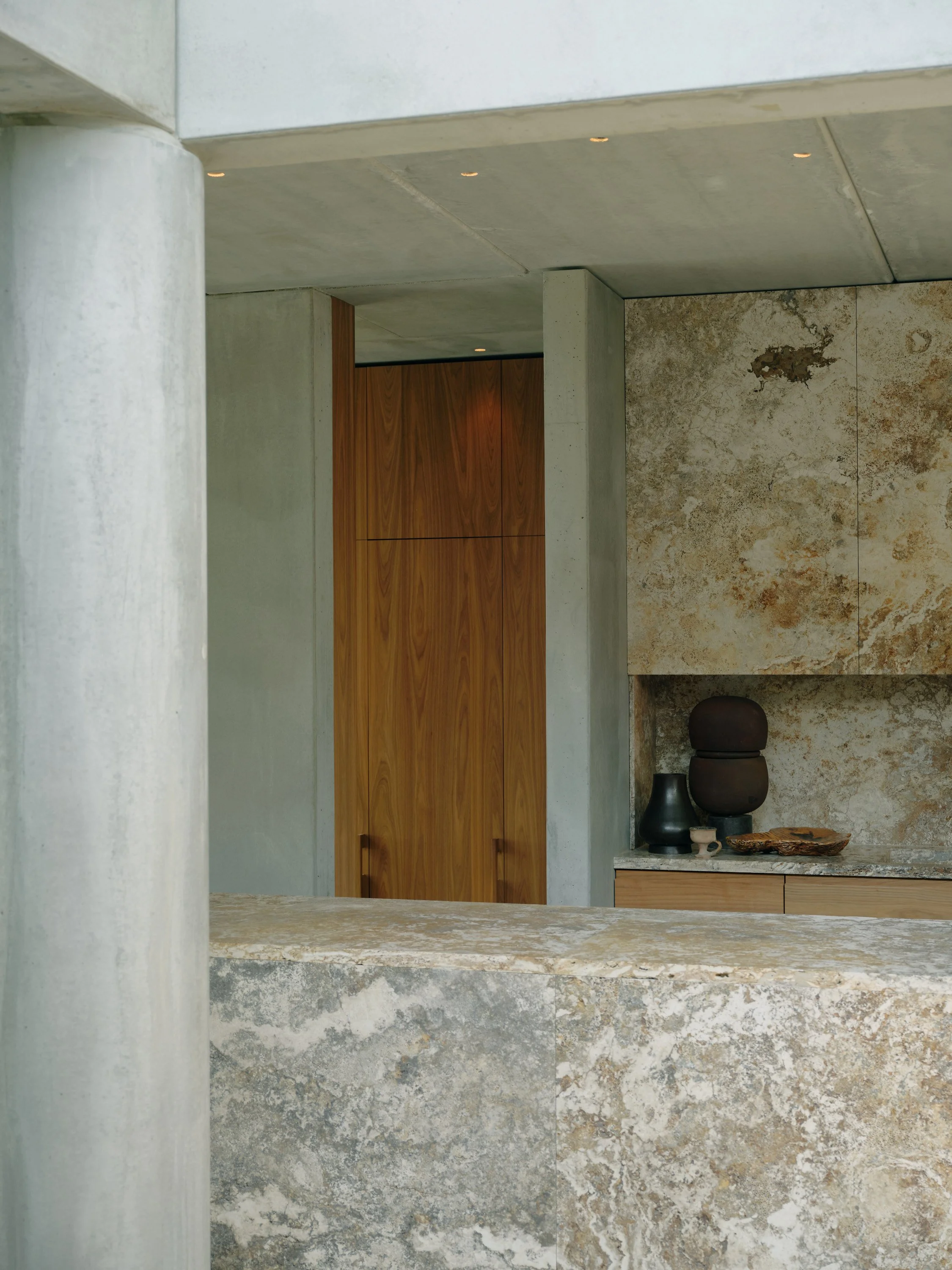 A floor to ceiling walk-in butlers pantry complimenting the main kitchen. Contrasting warmth of the Walnut agains the exposed raw concrete structure.