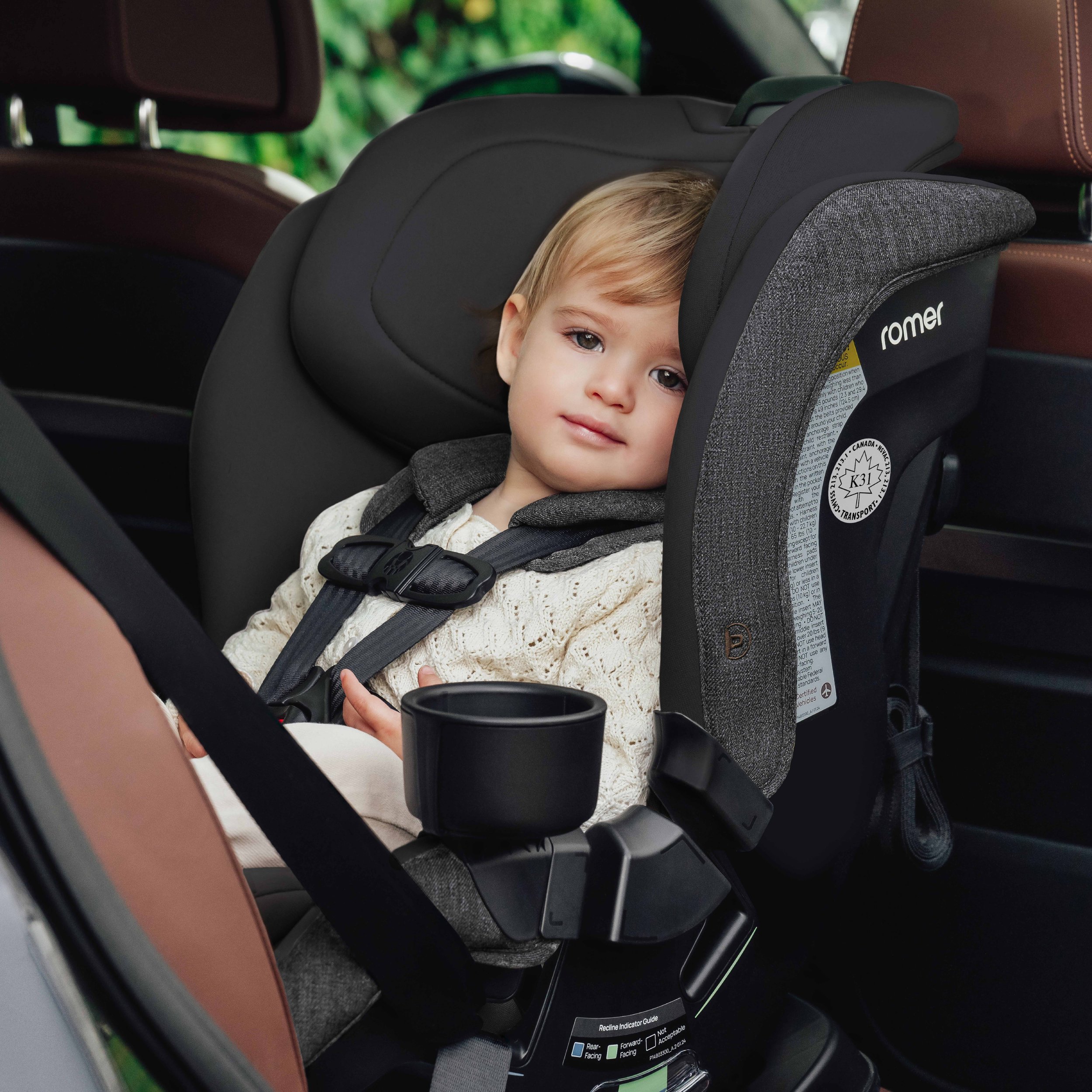 A toddler in a convertible car seat.