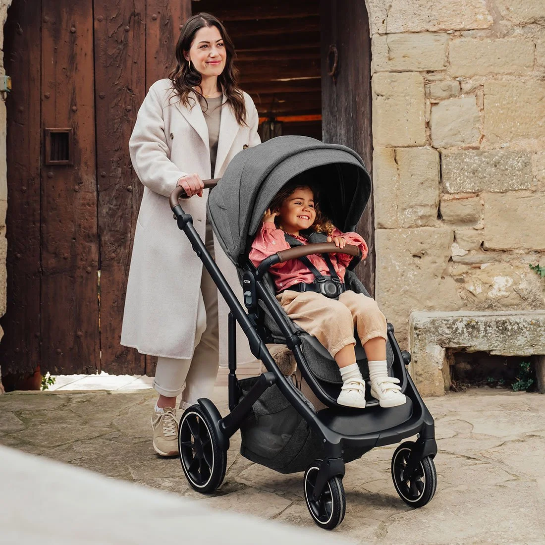 A woman pushing a baby stroller.