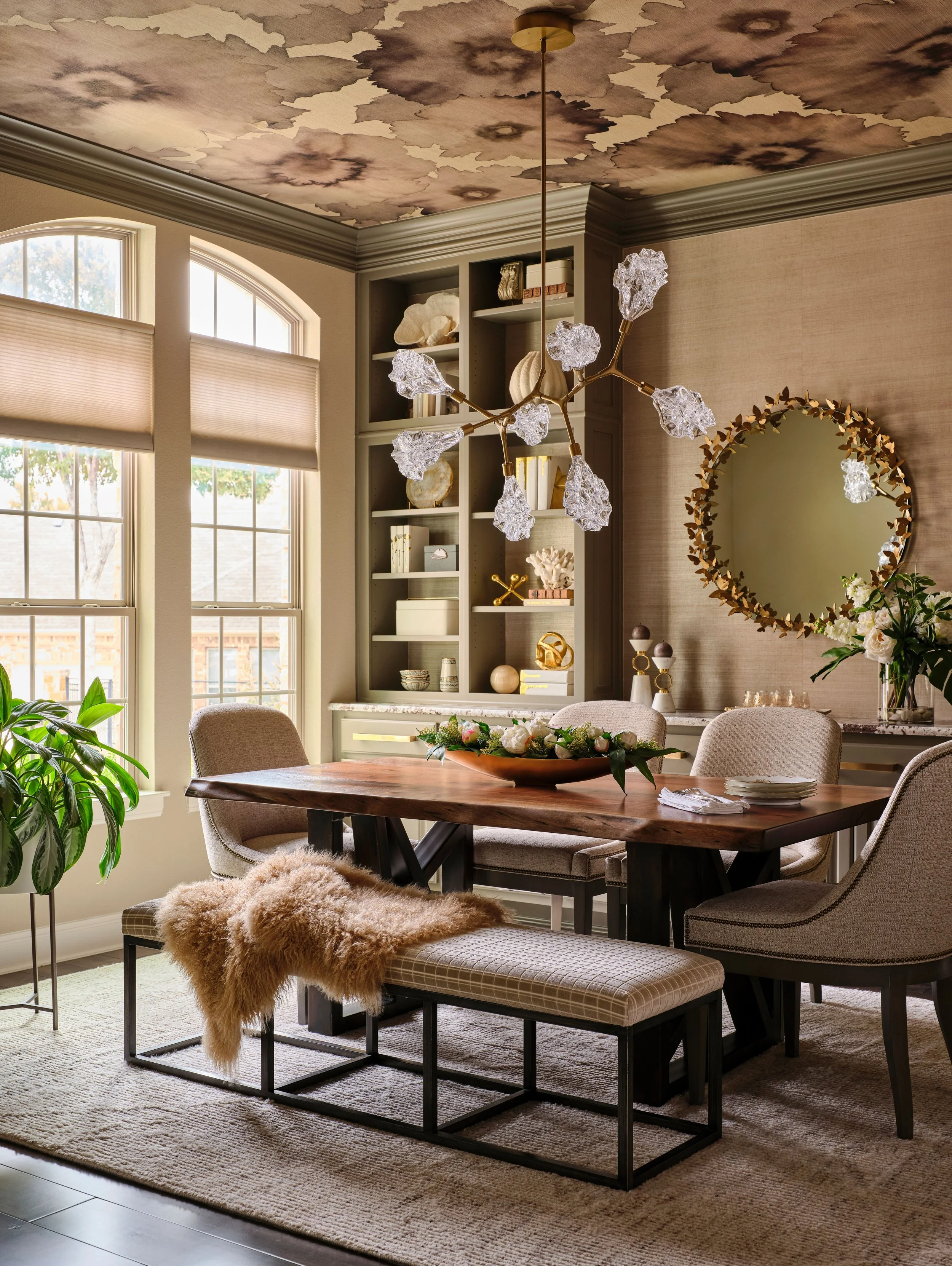 A custom ceiling treatment paired with sculptural lighting creates a defining moment in this dining room. The layered design draws the eye upward while adding warmth and dimension, reinforcing the sense of quiet luxury throughout the space.