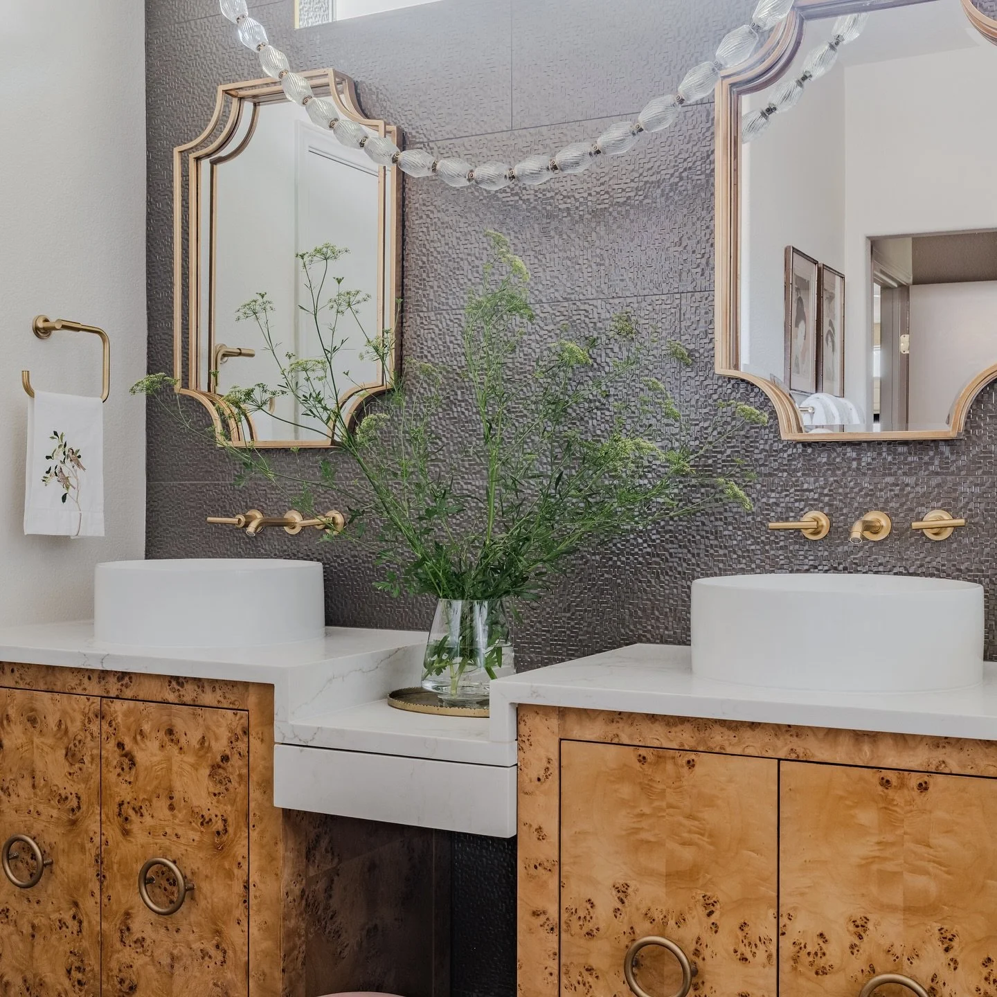 Burlwood, marble, brass, and texture create the perfect recipe for a vanity that feels timeless and luxe. Every detail, from the crystal lighting to the dimensional tile, was chosen to layer warmth, character, and quiet luxury into this custom bathro