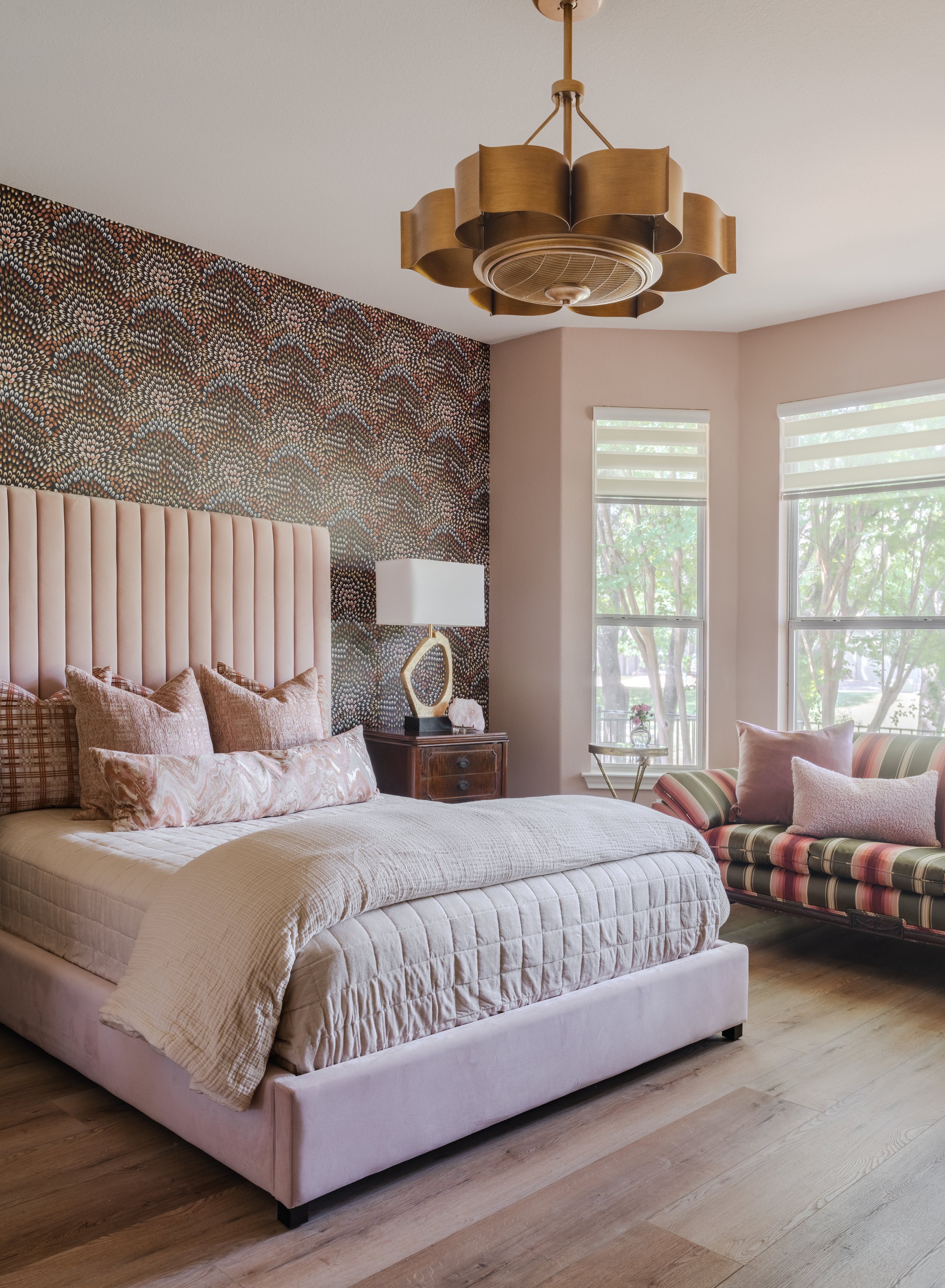 Layered bedroom interior with patterned wallcovering and upholstered bed in Sun City Georgetown Texas home by Cyndi Hopkins Design.