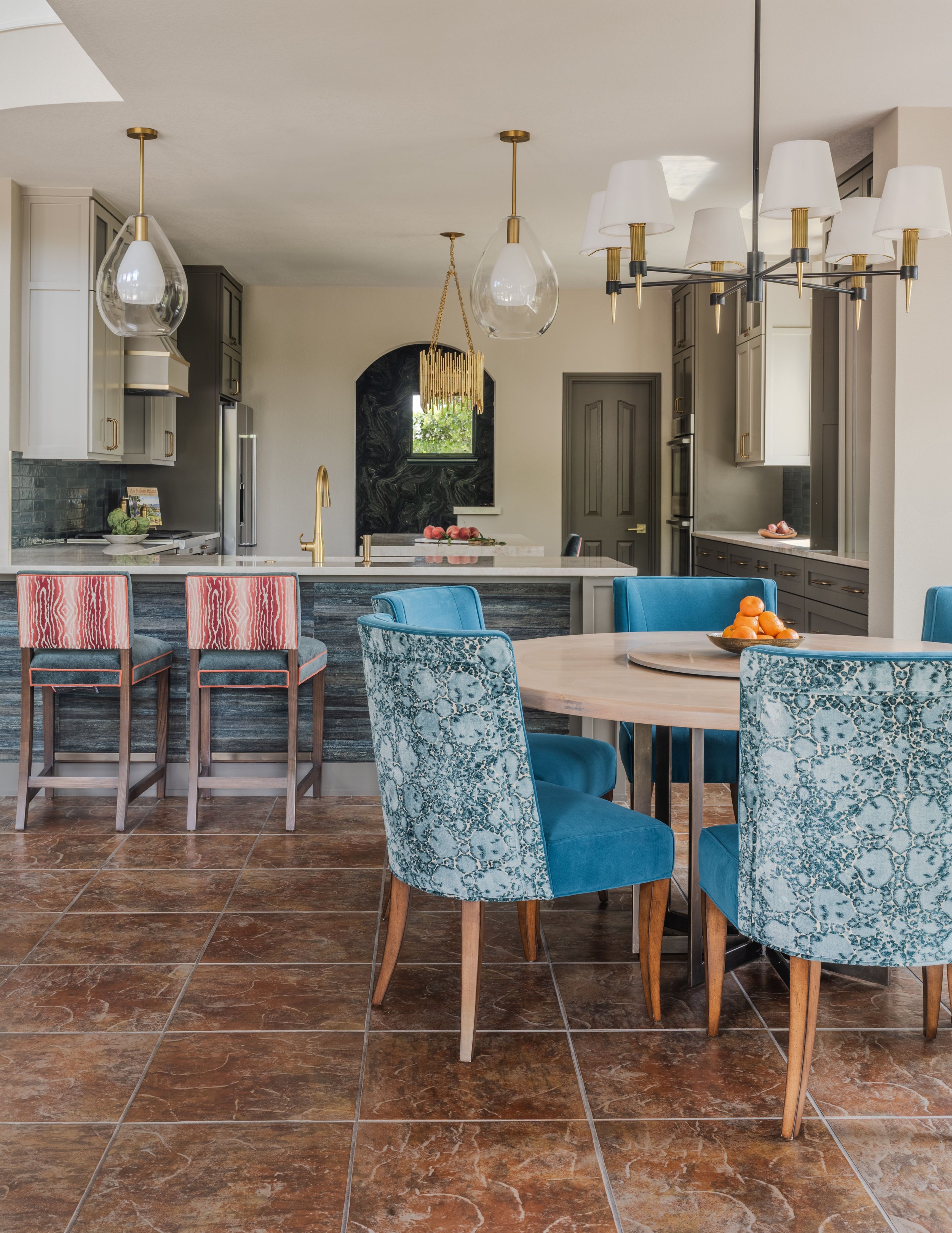 This open concept kitchen and breakfast room at the Schug Cove project was designed to feel cohesive, welcoming, and highly functional for everyday living and entertaining. Cyndi Hopkins Design layered custom furnishings, tailored seating, and rich b