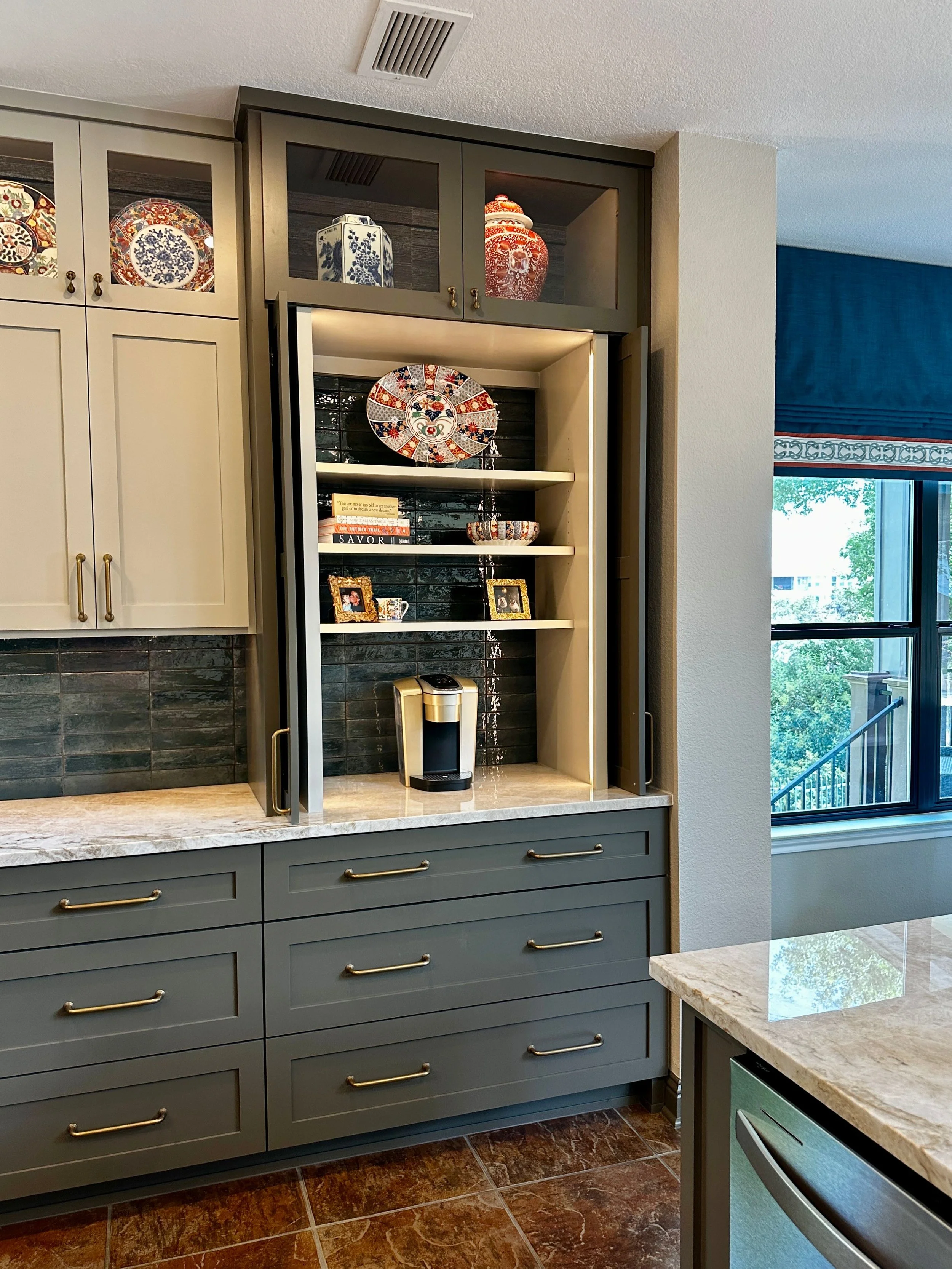 This custom kitchen coffee bar at the Schug Cove project blends built in cabinetry, handcrafted blue tile, and quartzite countertops to create a functional yet beautifully layered storage feature. Cyndi Hopkins Design incorporated tailored cabinetry,