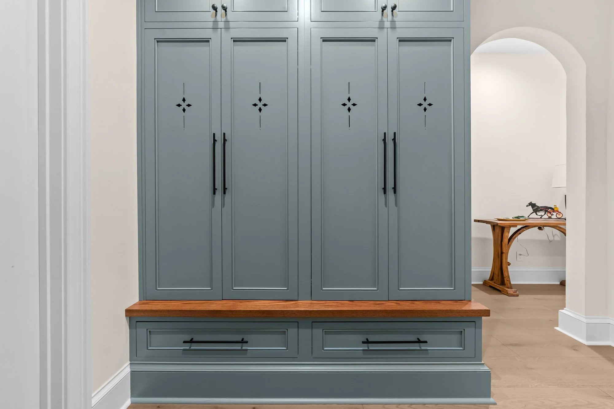 Custom mudroom by FRS Homes featuring built-in blue storage lockers, wood bench seating, and handcrafted cabinetry designed for organized everyday living.