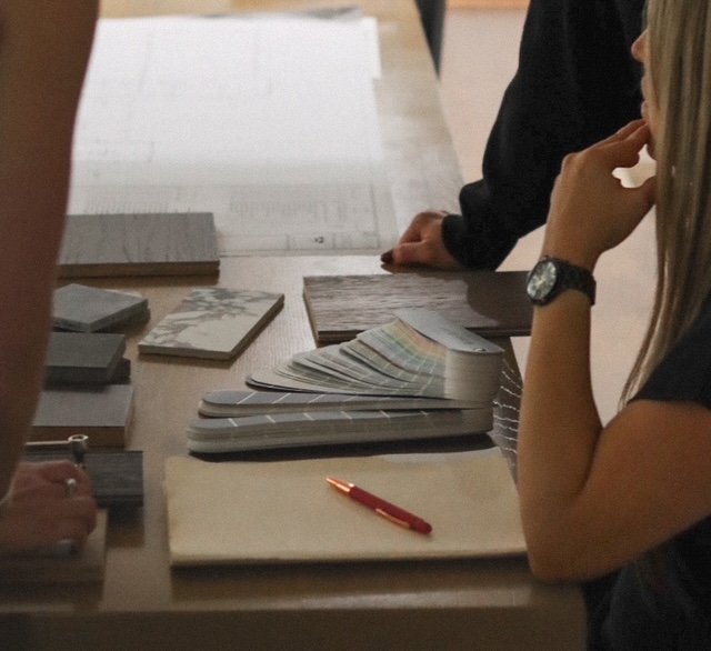 FRS Homes team selecting paint swatches, tile samples, and wood finishes during a custom home planning session.