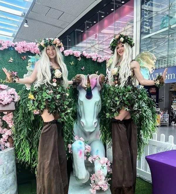 Actors in colorful fairy costumes with wings, floral headdresses, and leaf skirts. High end fairytale performers in fantasy costume. Luxury enchanted acts for events, film and TV casting.