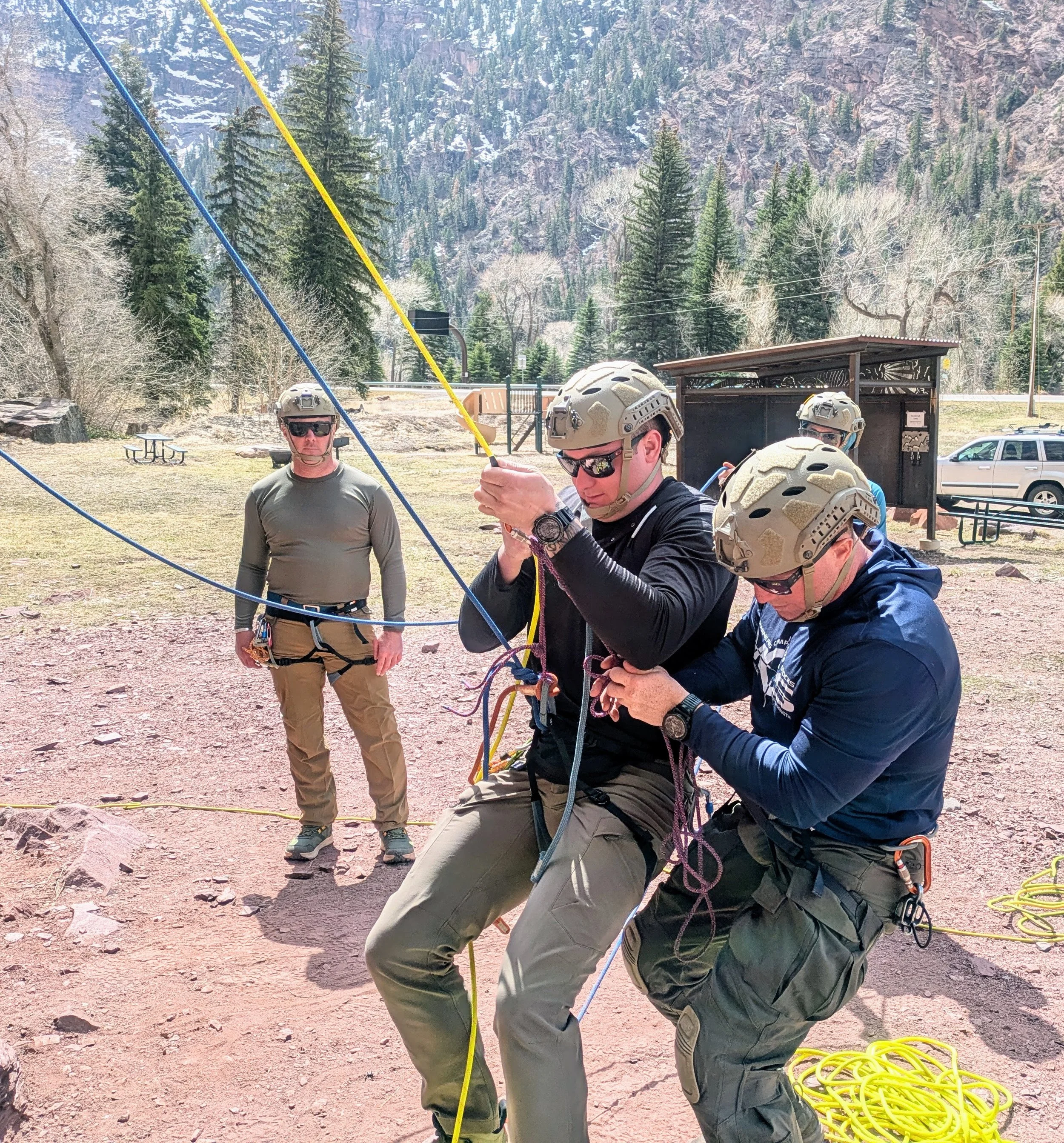 4 SWAT team members practicing rope rescue in a park