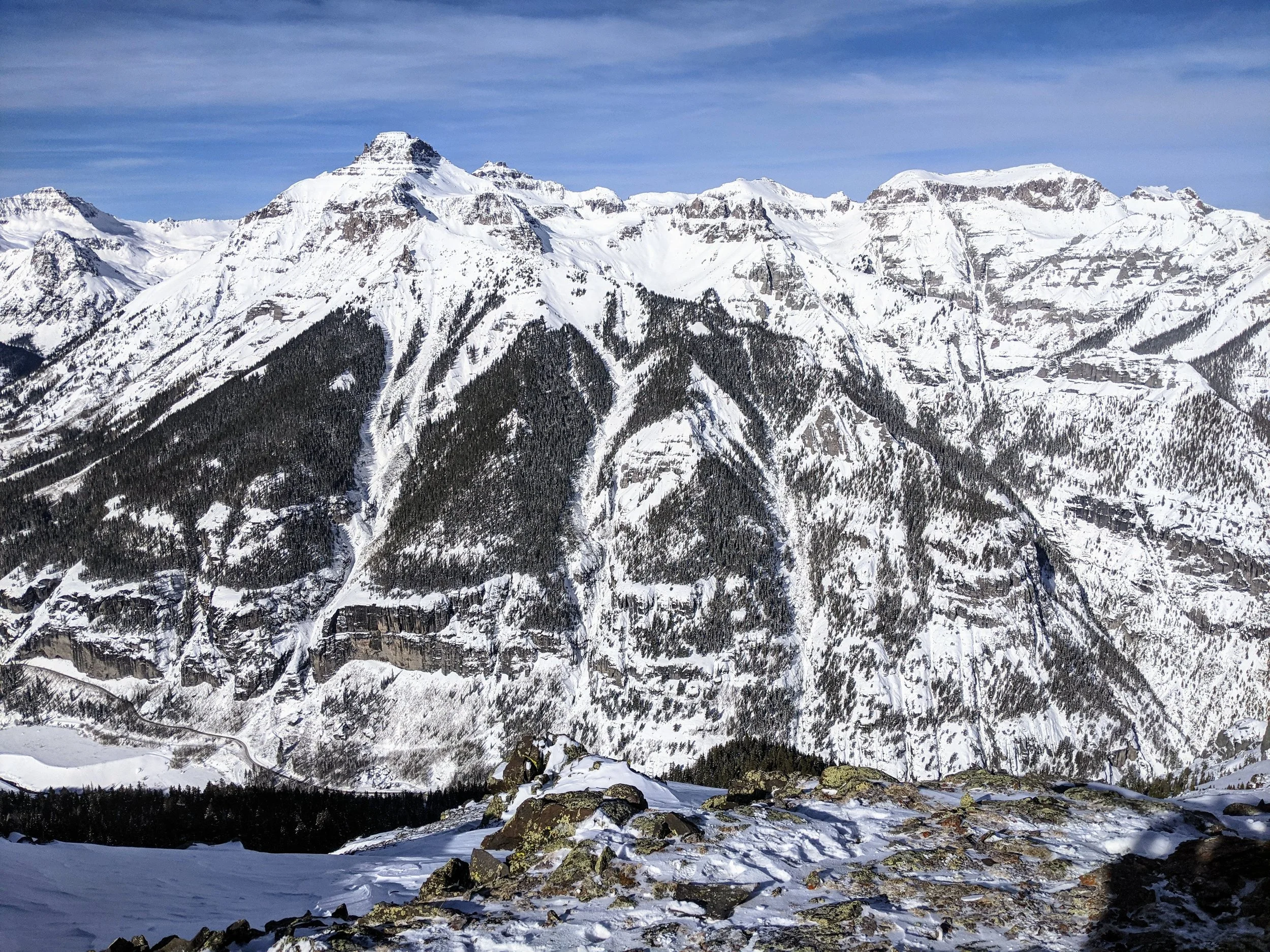 avalanche forecaster view multiple avalanche paths in Colorado mountains threating a road to a mine