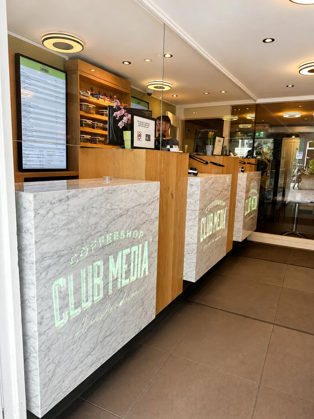 Het warme houten interieur, de hanglampen en de marmeren balie van Club Media