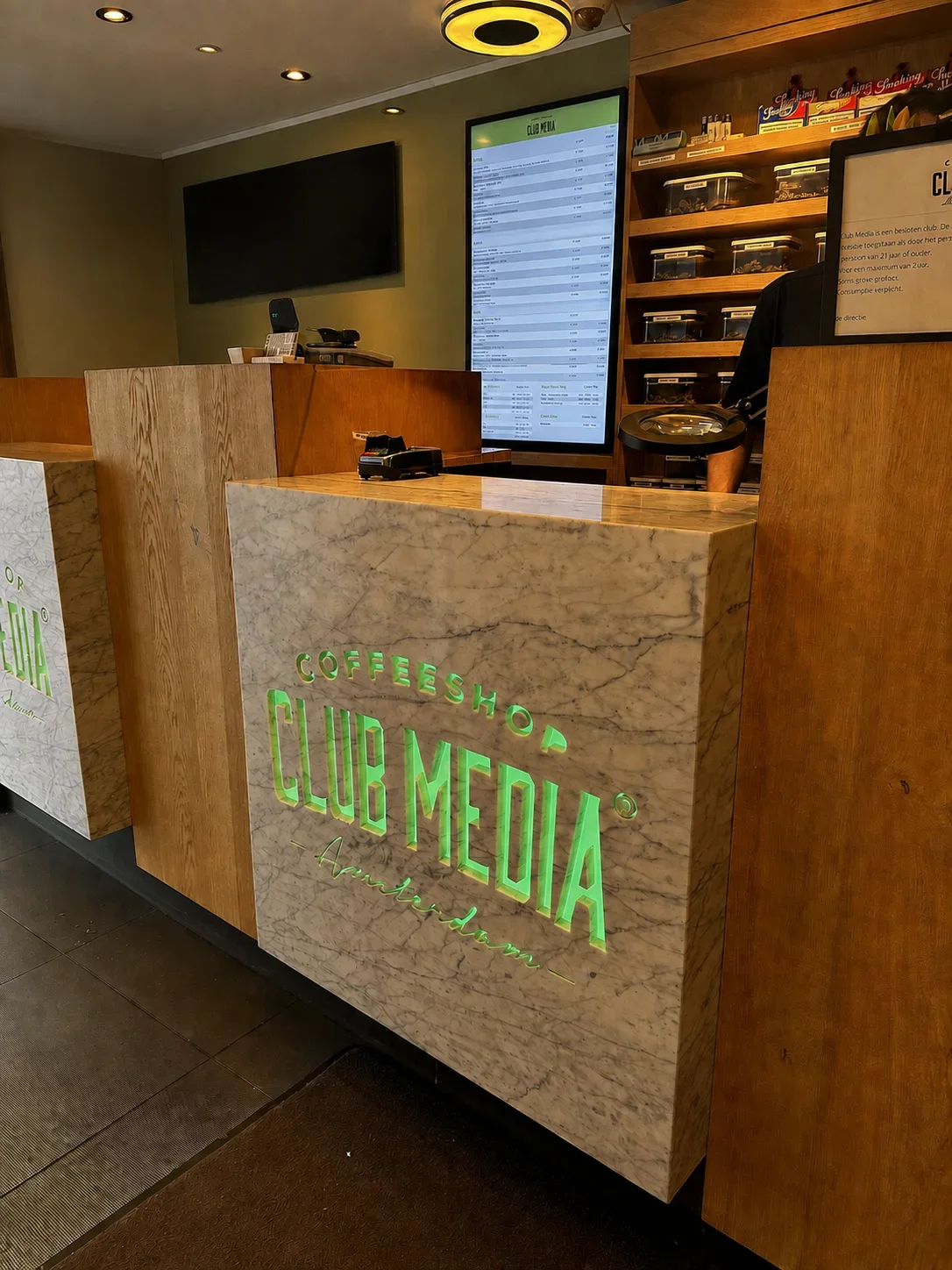 The wood and marble counter with the Club Media logo inside the store