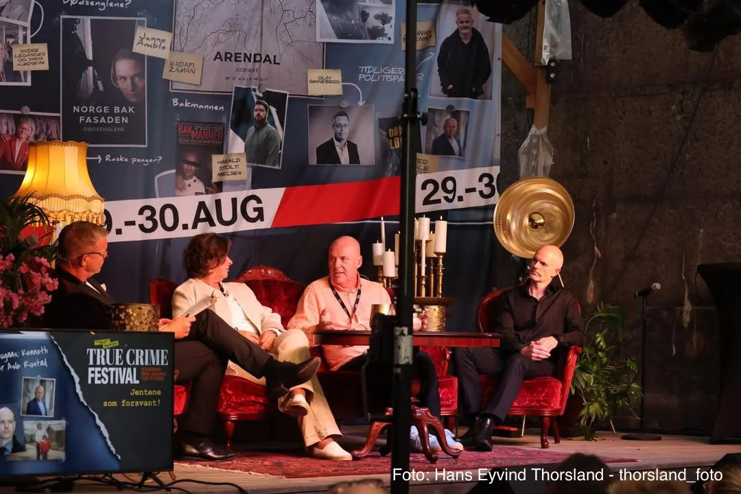 Scenepanel under True Crime Festival med fire personer sittende i røde salongstoler på en opplyst scene. Bak dem henger en stor bakvegg dekorert med bilder, kart og tekst om forsvinningssaker og tidligere politisaker.