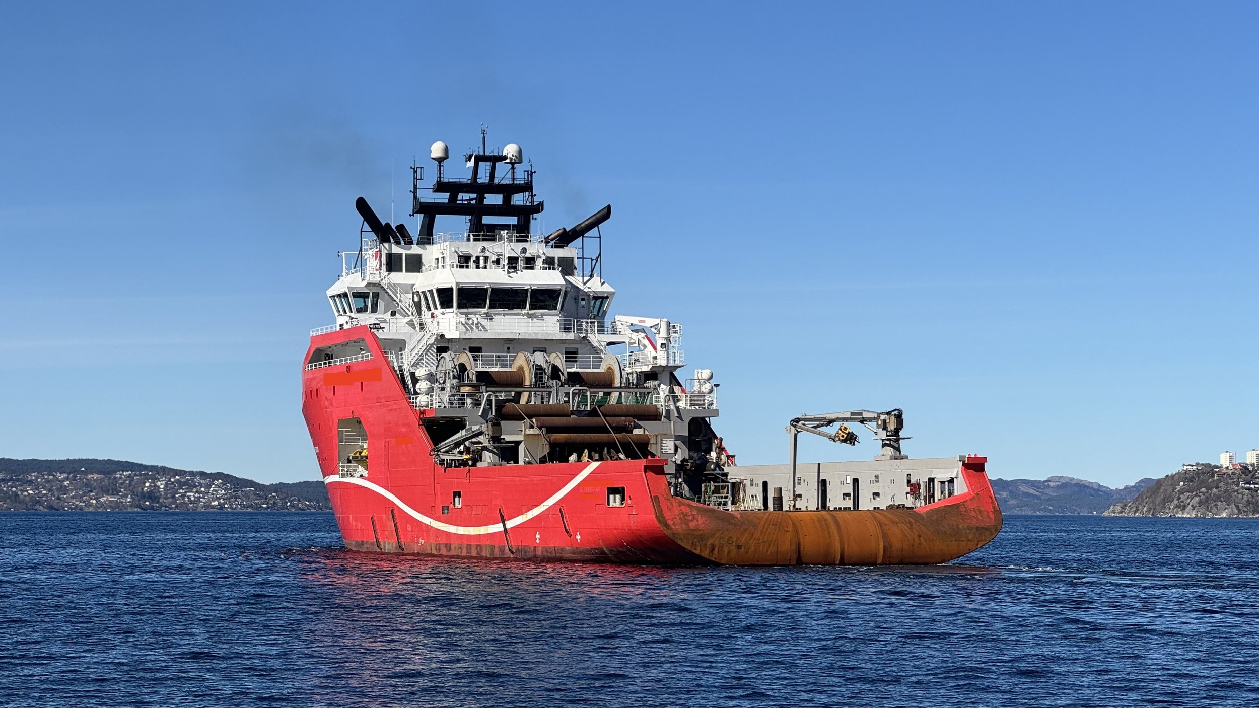 Rødt supply skip brukt i shipping og offshore, relatert til Privatgranskeren AS og privatetterforskning i maritim sektor.