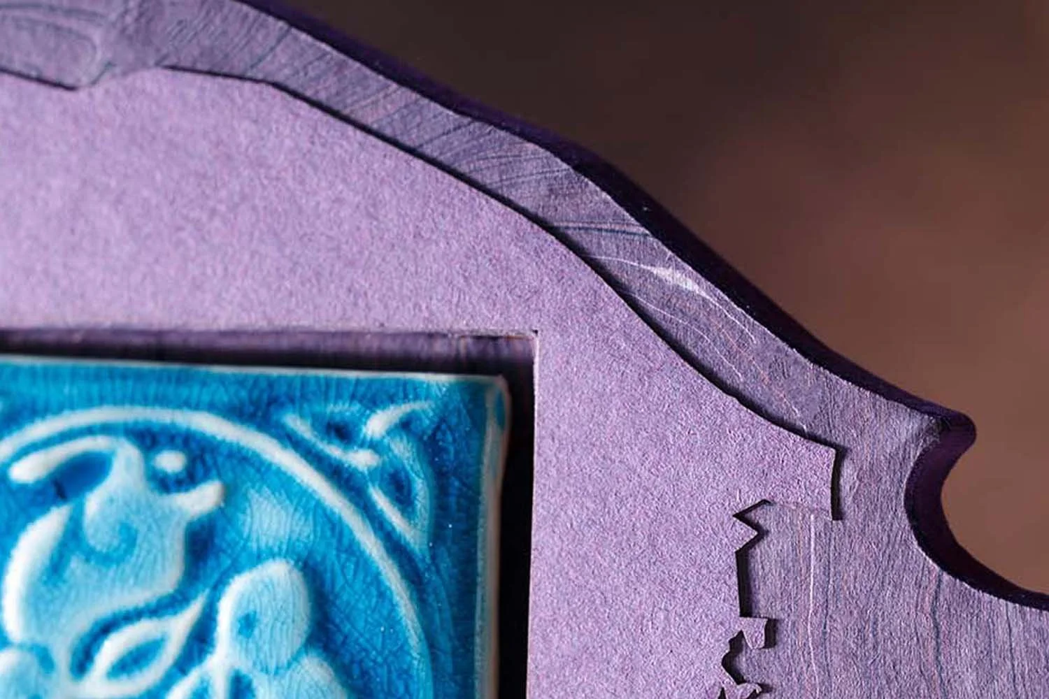 Close-up of a custom wedding guest book sign featuring layered paper construction, handcrafted ceramic tile artwork, and sculptural reception signage details.