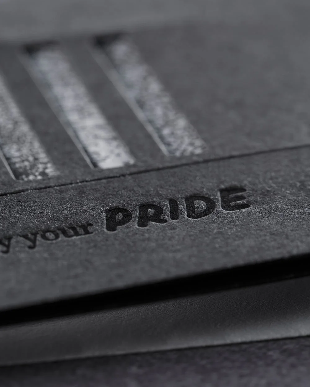 Letterpress detail of the word “Pride” on the interactive Pride Ally Card by Lucasano Creative.