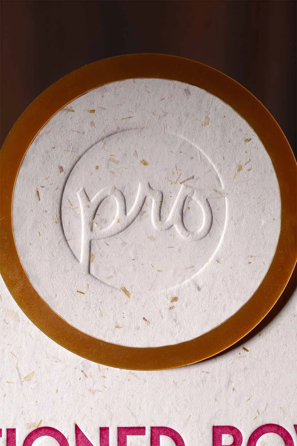 Embossed logo detail on custom Art Deco wedding signage featuring handmade paper, layered acrylic framing, and tactile design elements.