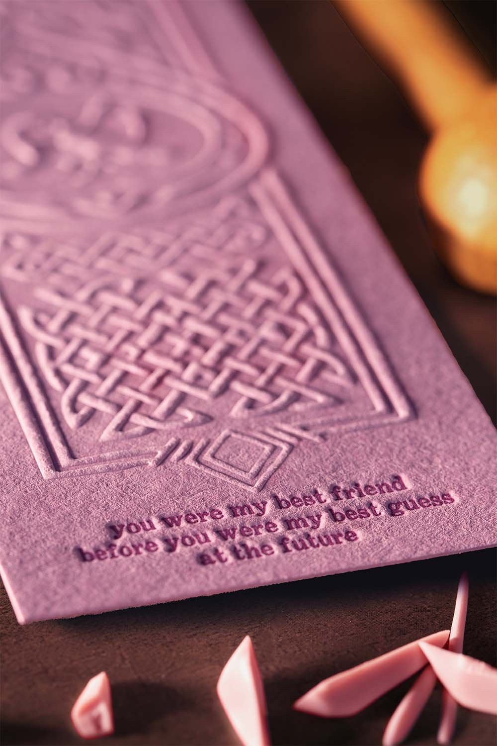 Close-up of blind embossed wedding invitation on blush pink cotton paper featuring Celtic-inspired artwork and tactile letterpress details by Lucasano Creative.