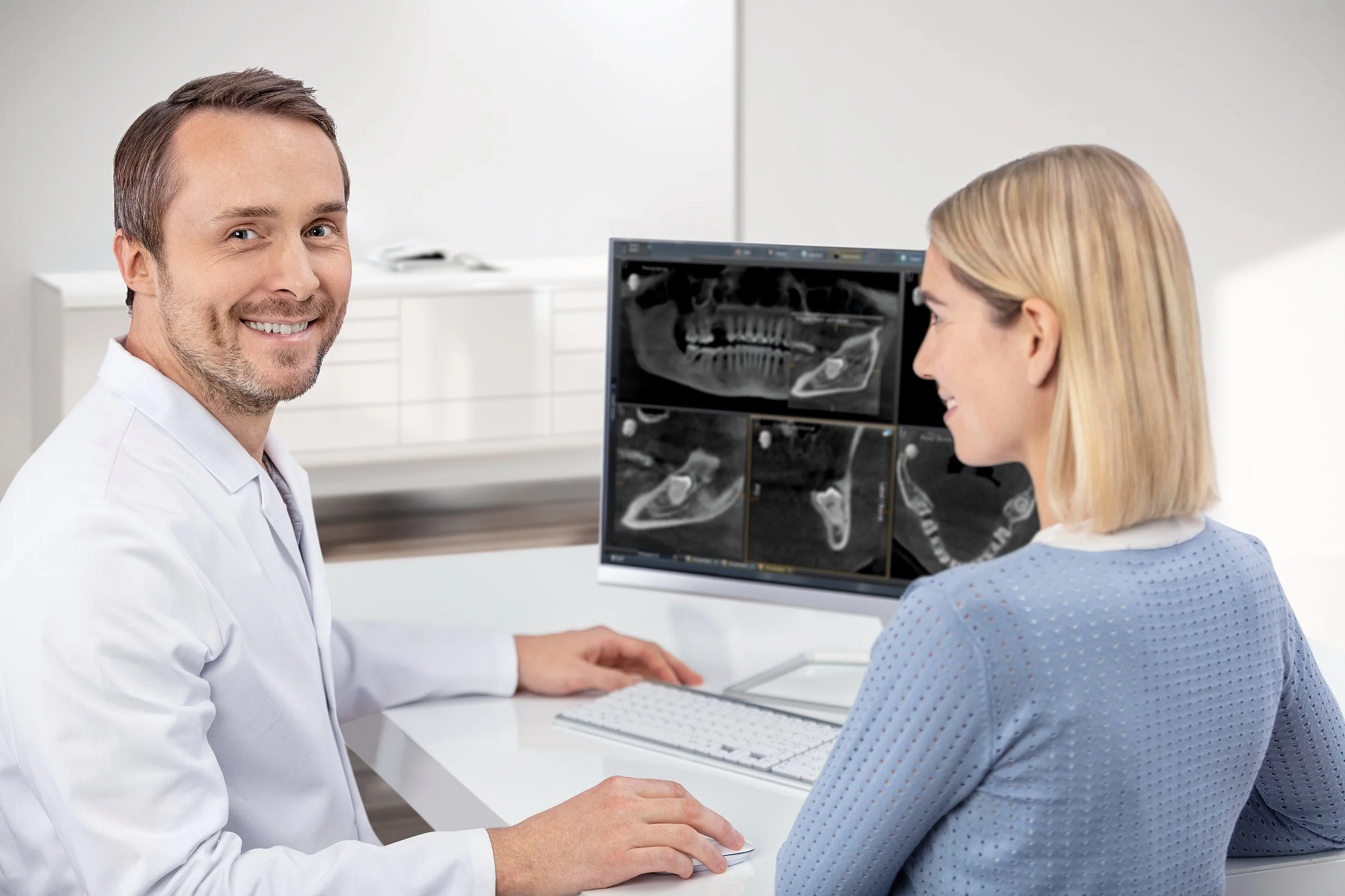Doctor and female patient looking at dental X-ray scans in a medical office.