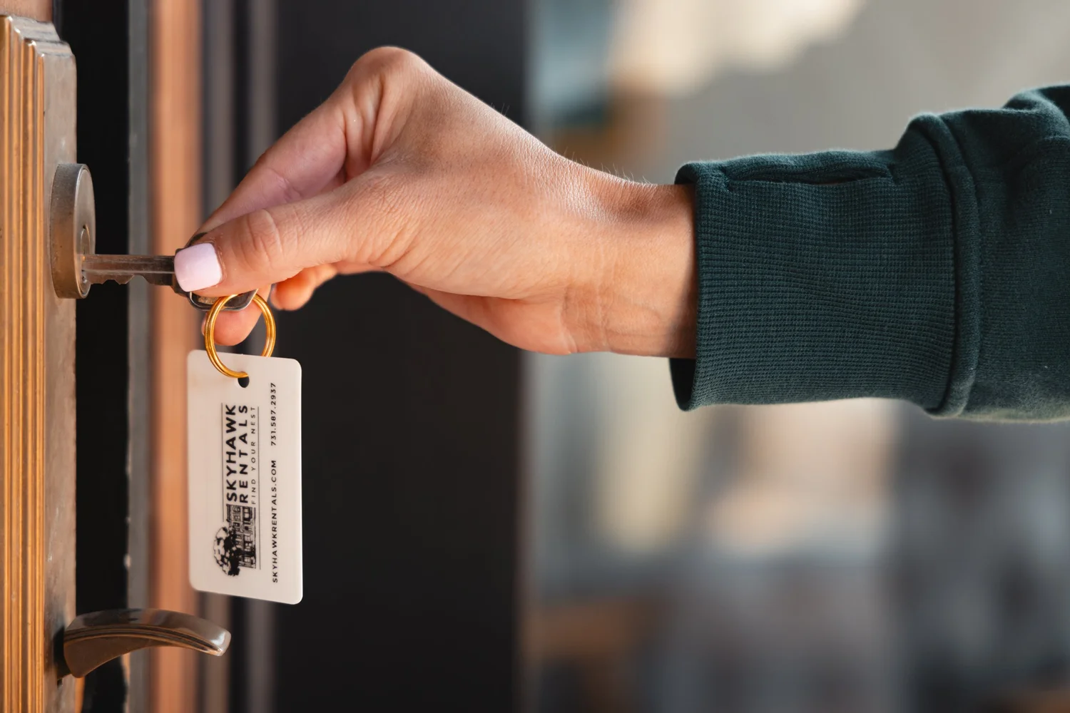 A key with a Skyhawk Rentals tag in a front door