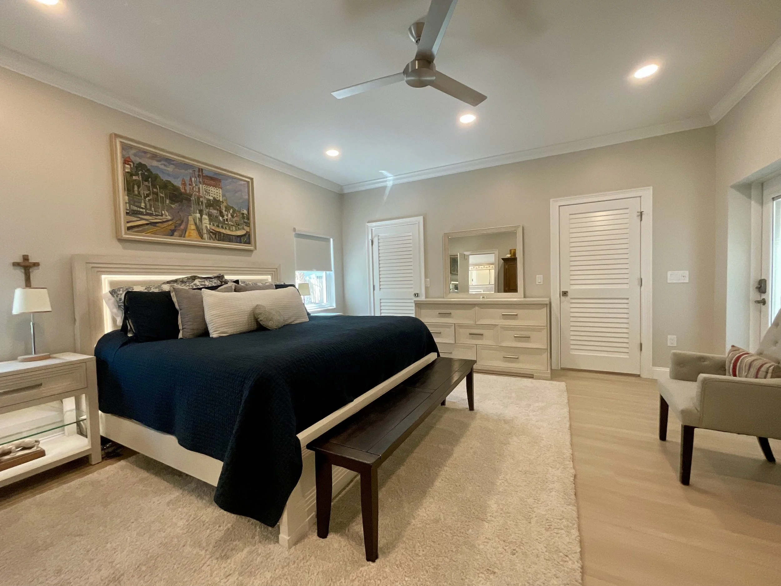 Bedroom addition with 10-foot ceilings, large bed, windows on either side, his and hers walk-in closets, and glass door to lanai.