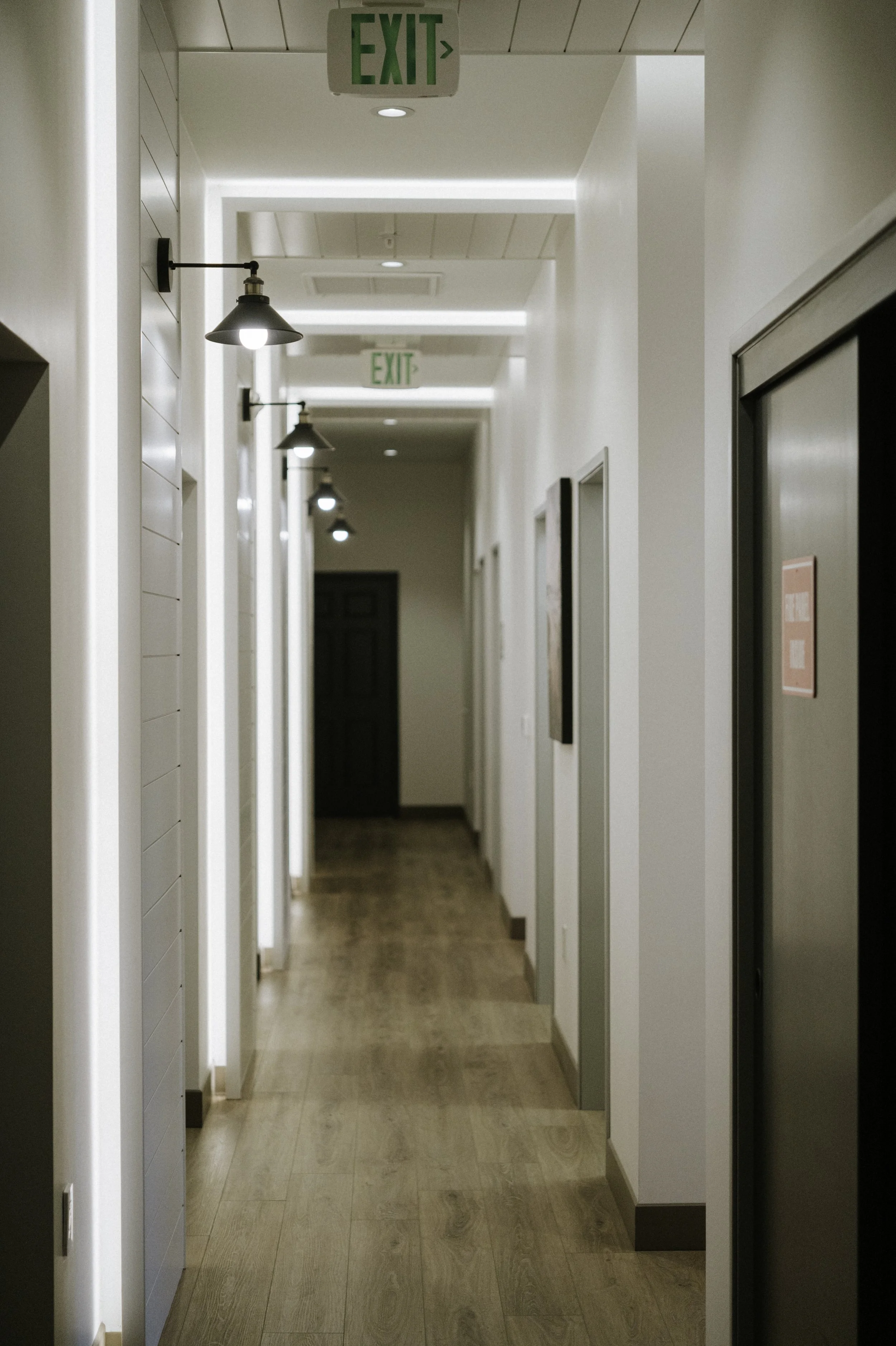 Black interior doors and lighting add to the farmhouse feel. Shiplap siding is accented by black sconces.