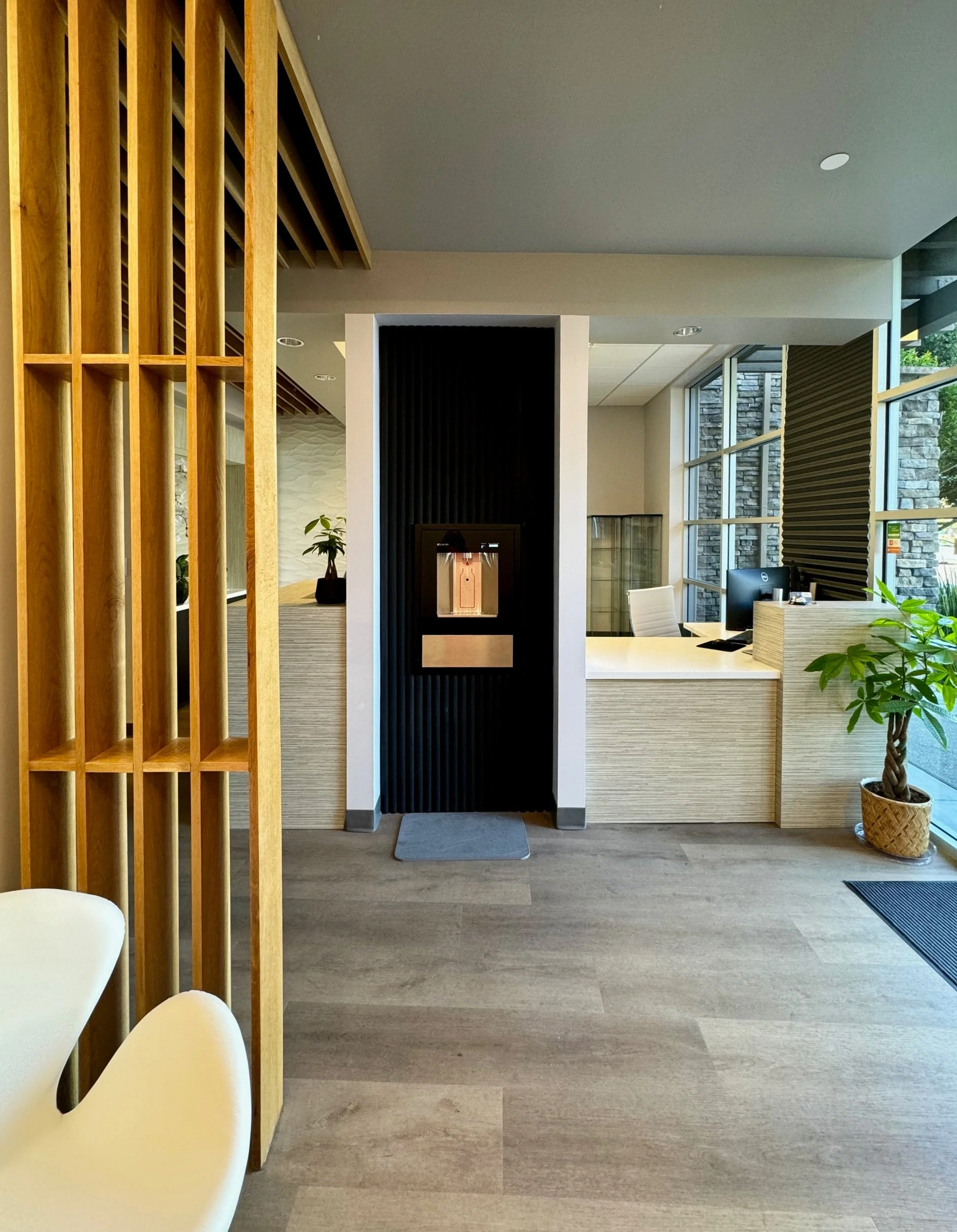 Japandi Dental Office using natural materials and textures. Bottle filler, acoustic beams, Bellavati countertop, tulip chair.