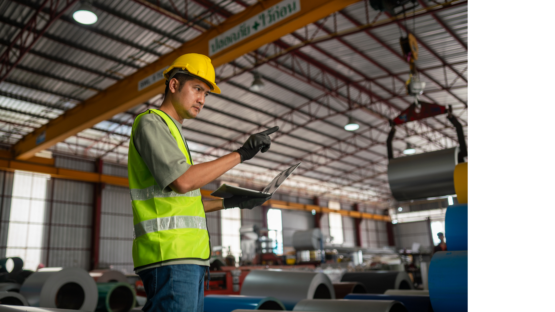 A man wearing PPE standing in a factory.