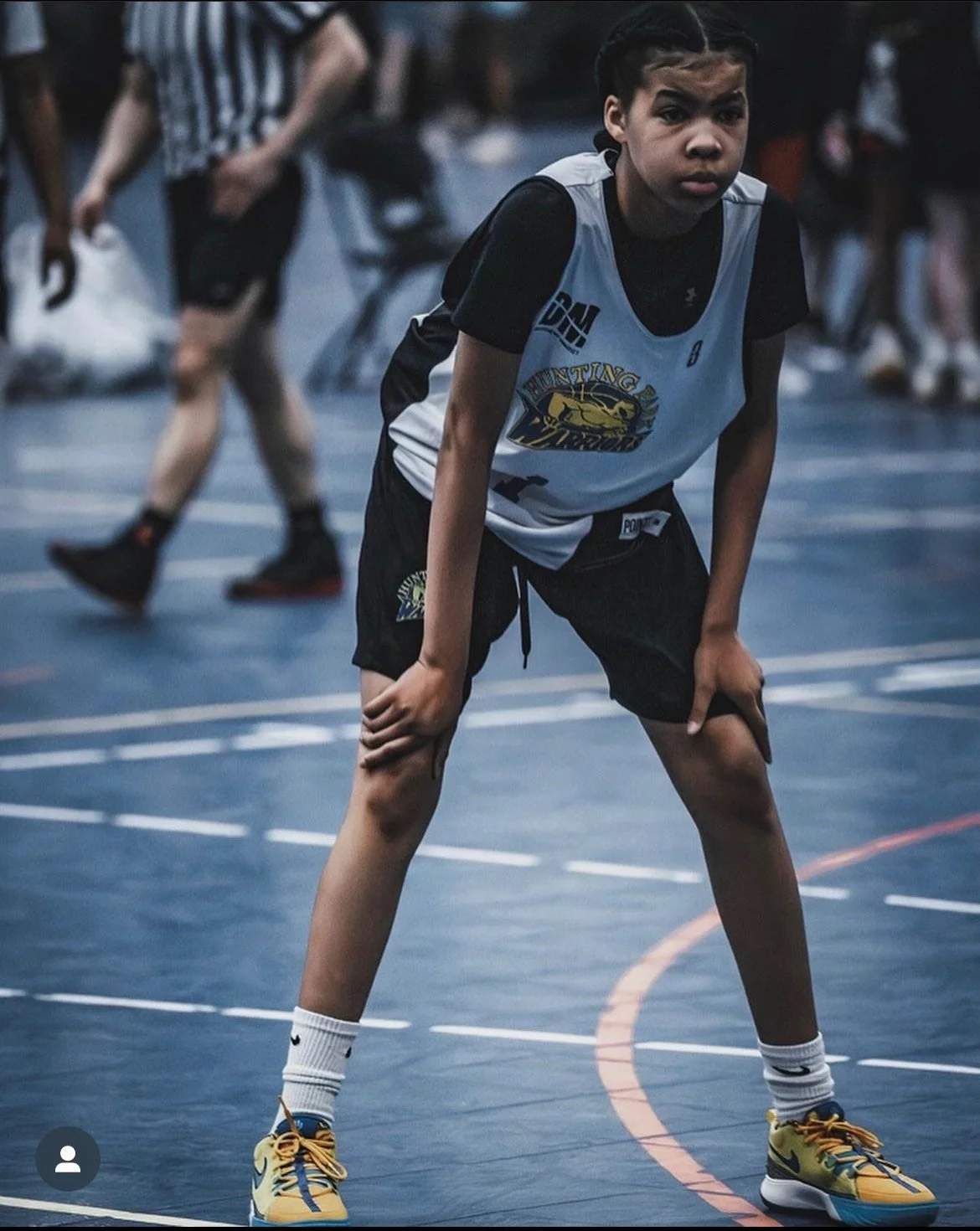 A young female, on a basketball court. 