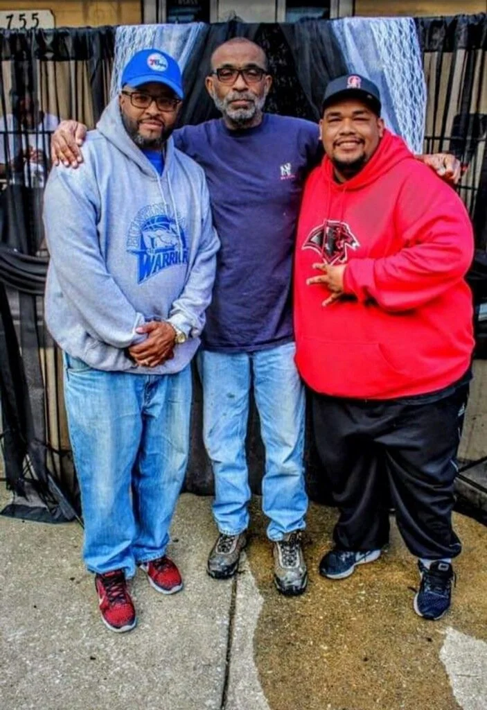 A picture of three black male coaches, wearing different colors. 