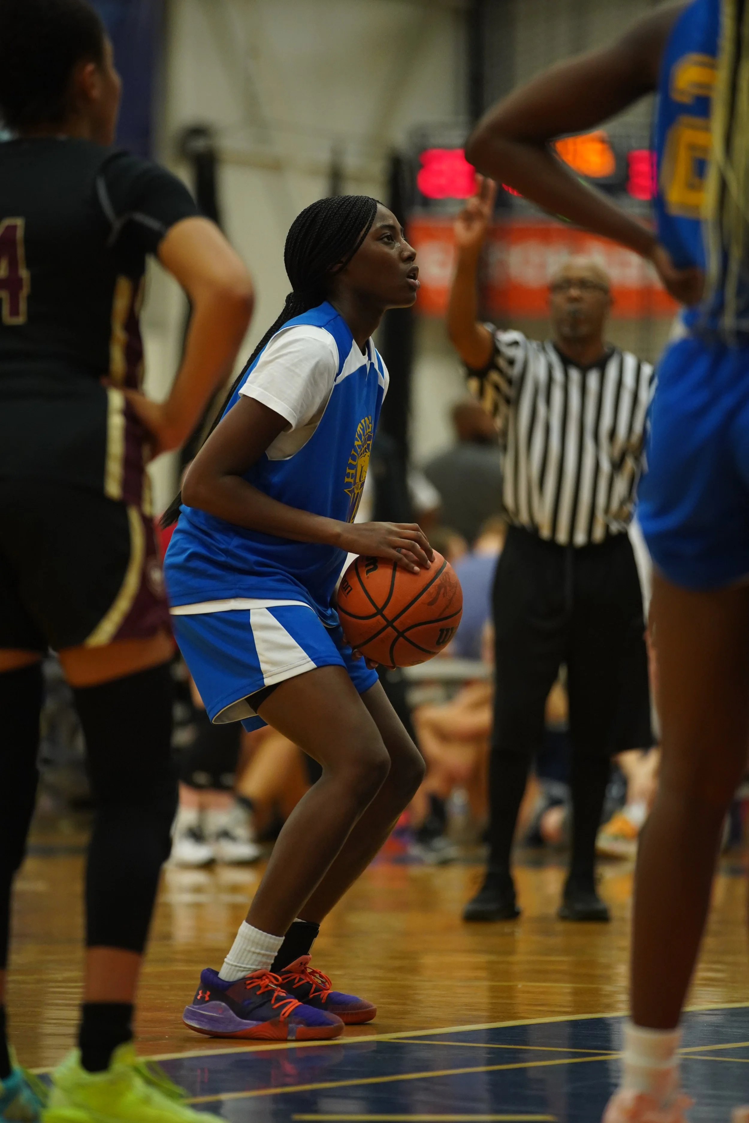 A young lady of preparing to shoot her basketball. With colors, blue and white. 