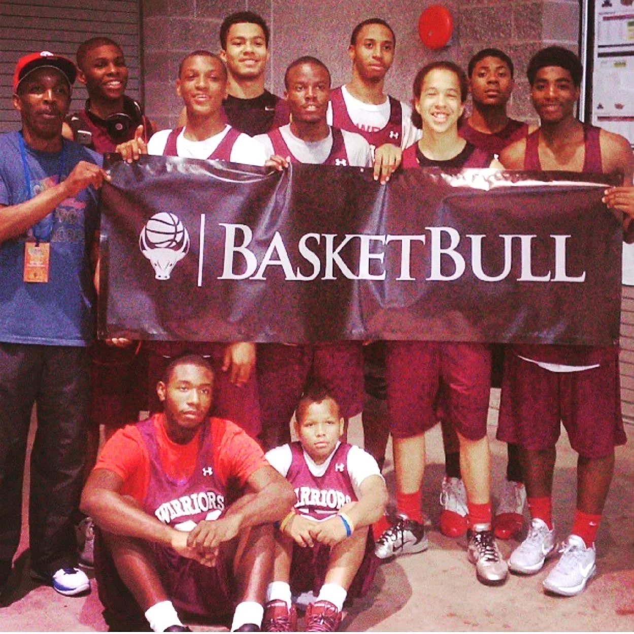 An old picture of a group of youth holding a banner that says basketball. 