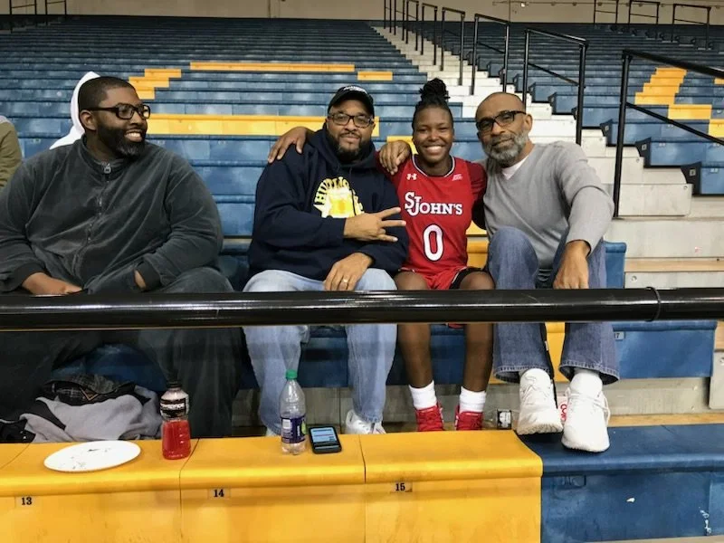A group of 3 guys with the warriors shirt. 