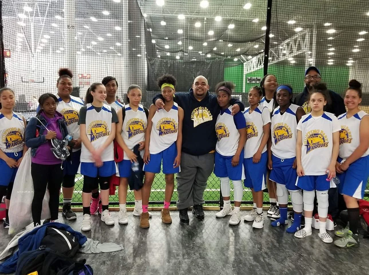 The female basketball team, with their coach in the middle of the picture and on the left. 