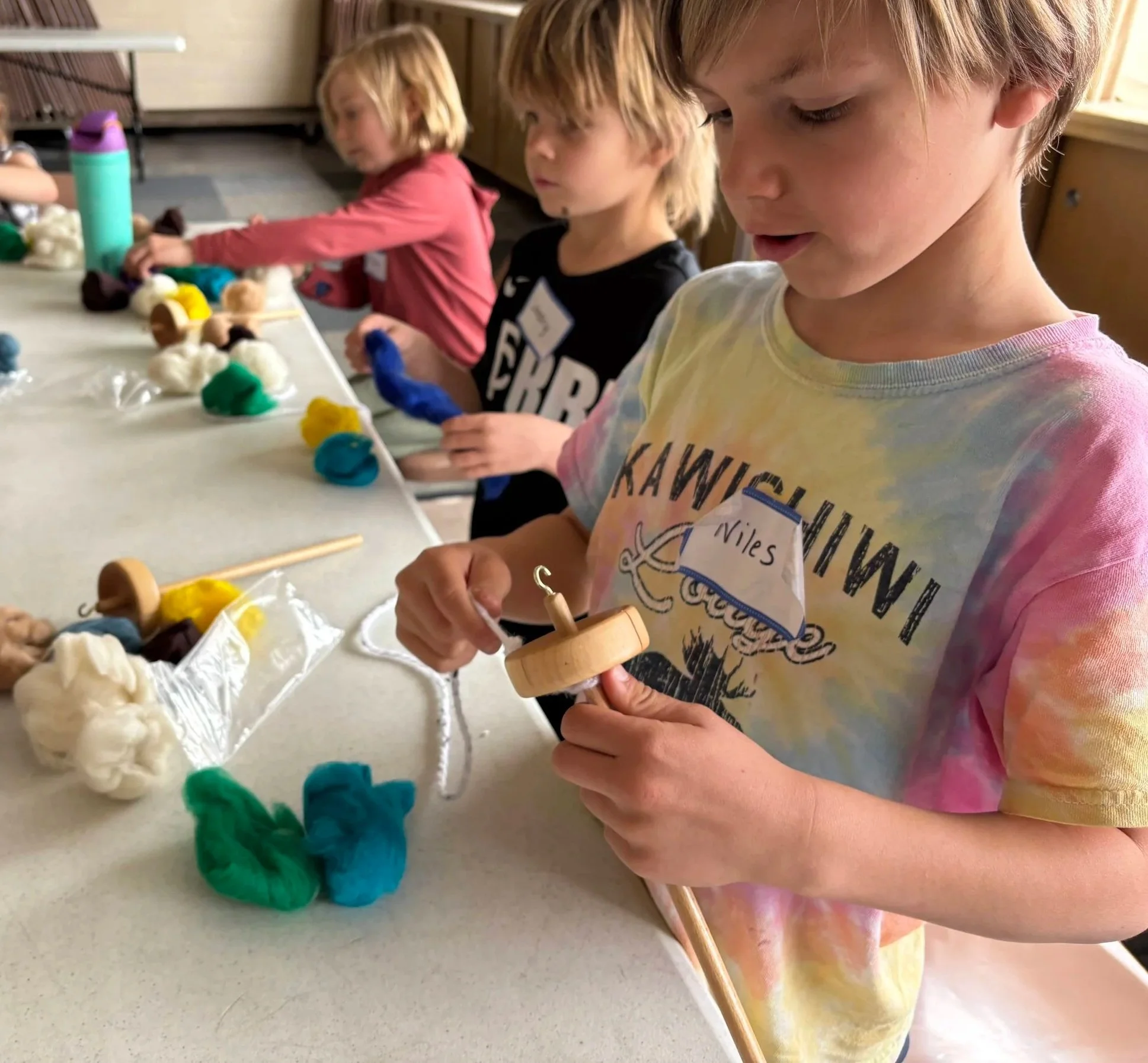 Mapmakers learning to make their own yarn with the Textile Center.