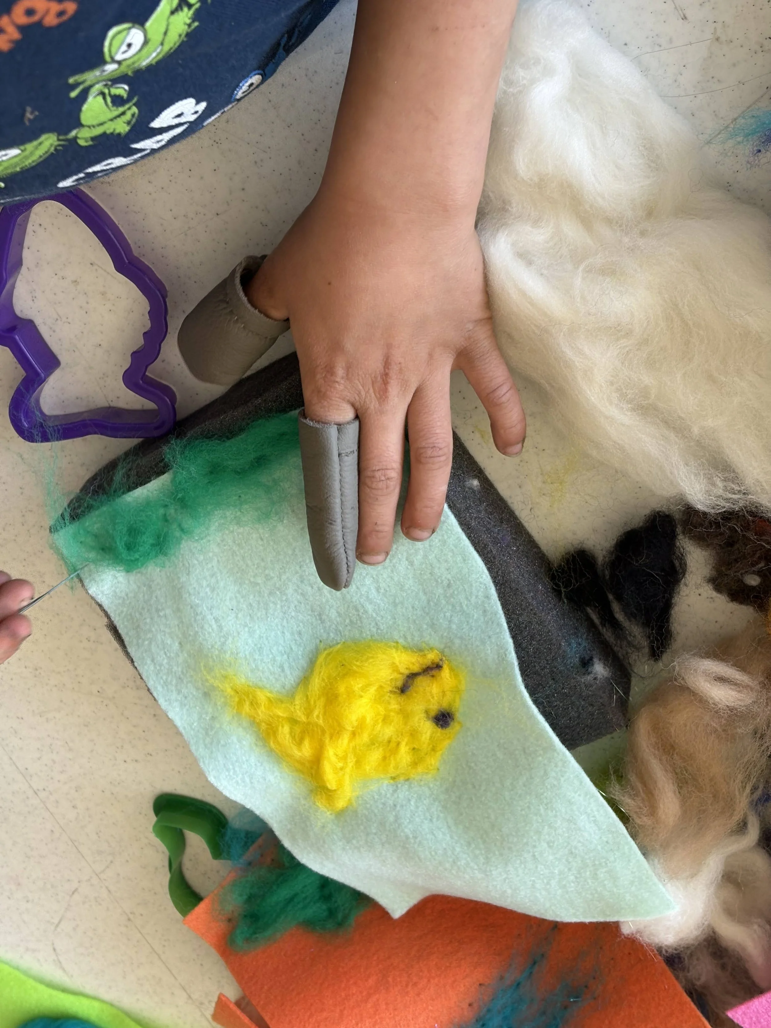 Mapmakers needle felting fish with the Textile Center.