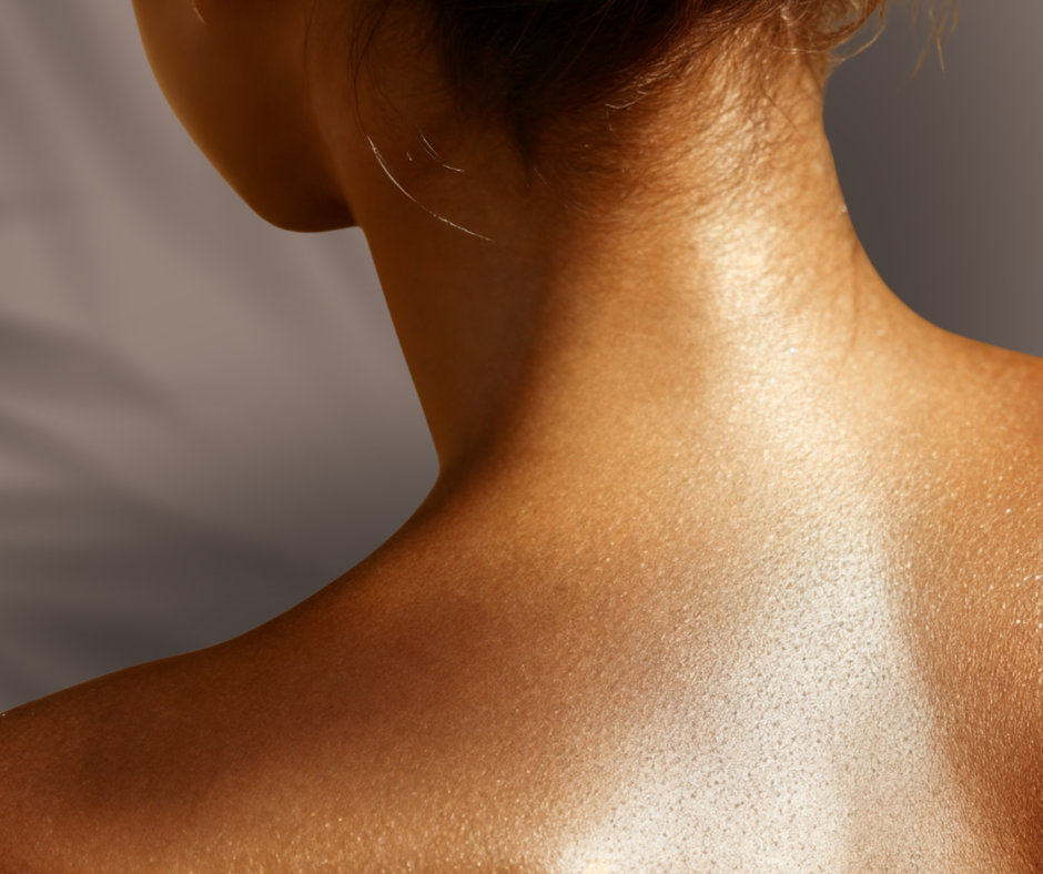 Close-up of a person's neck and shoulder with smooth, glistening skin and short, light brown hair.