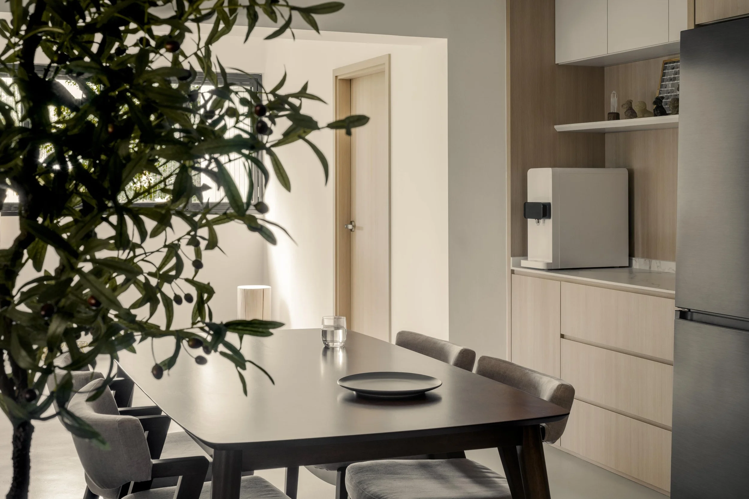 Modern dining room and open-concept kitchen designed by Lite Design Collaborative (LDC) in Singapore, featuring minimalist cabinetry, integrated appliances, and a contemporary dining table.