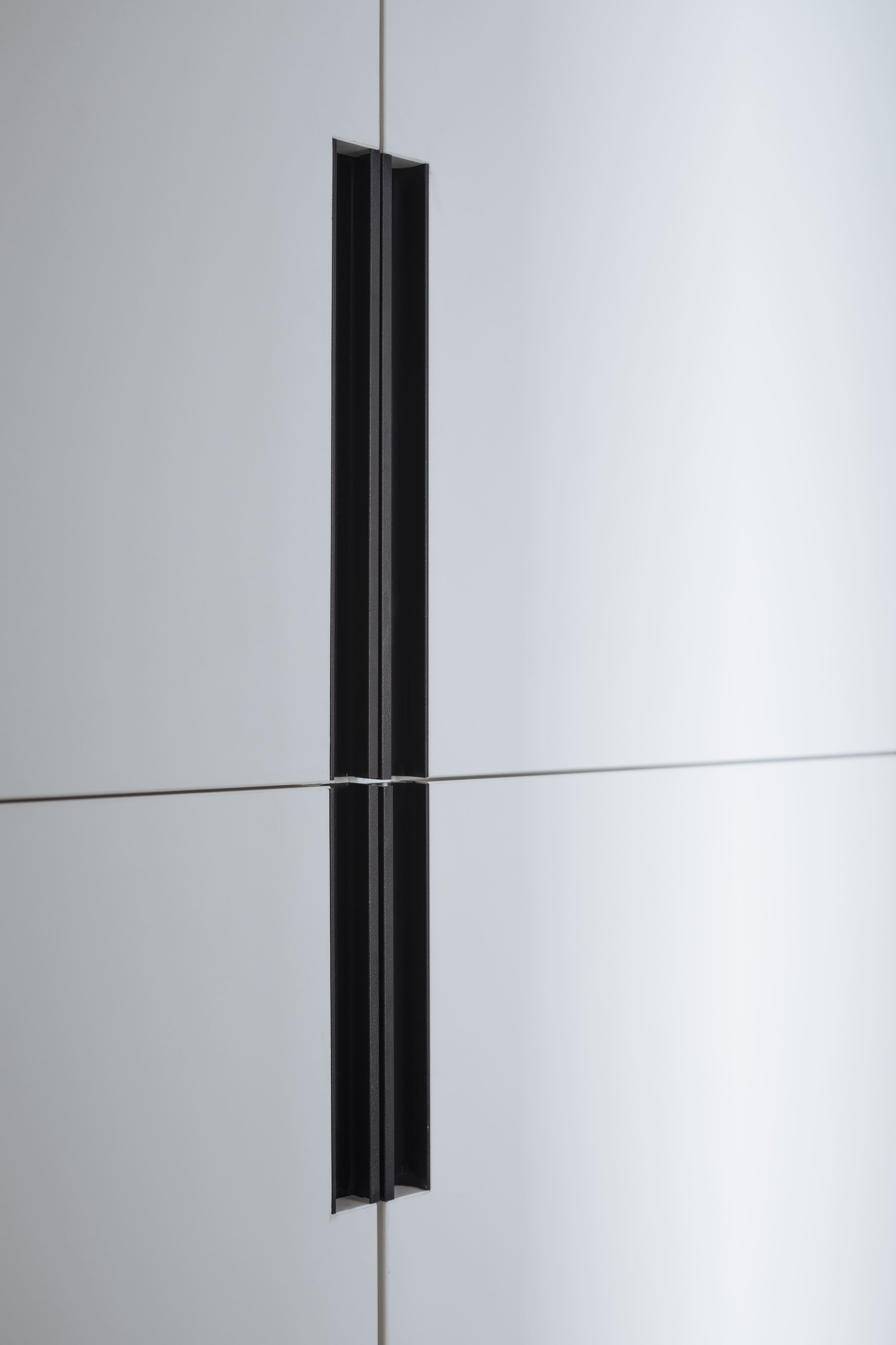 Close-up of modern recessed cabinet handle in minimalist built-in storage.