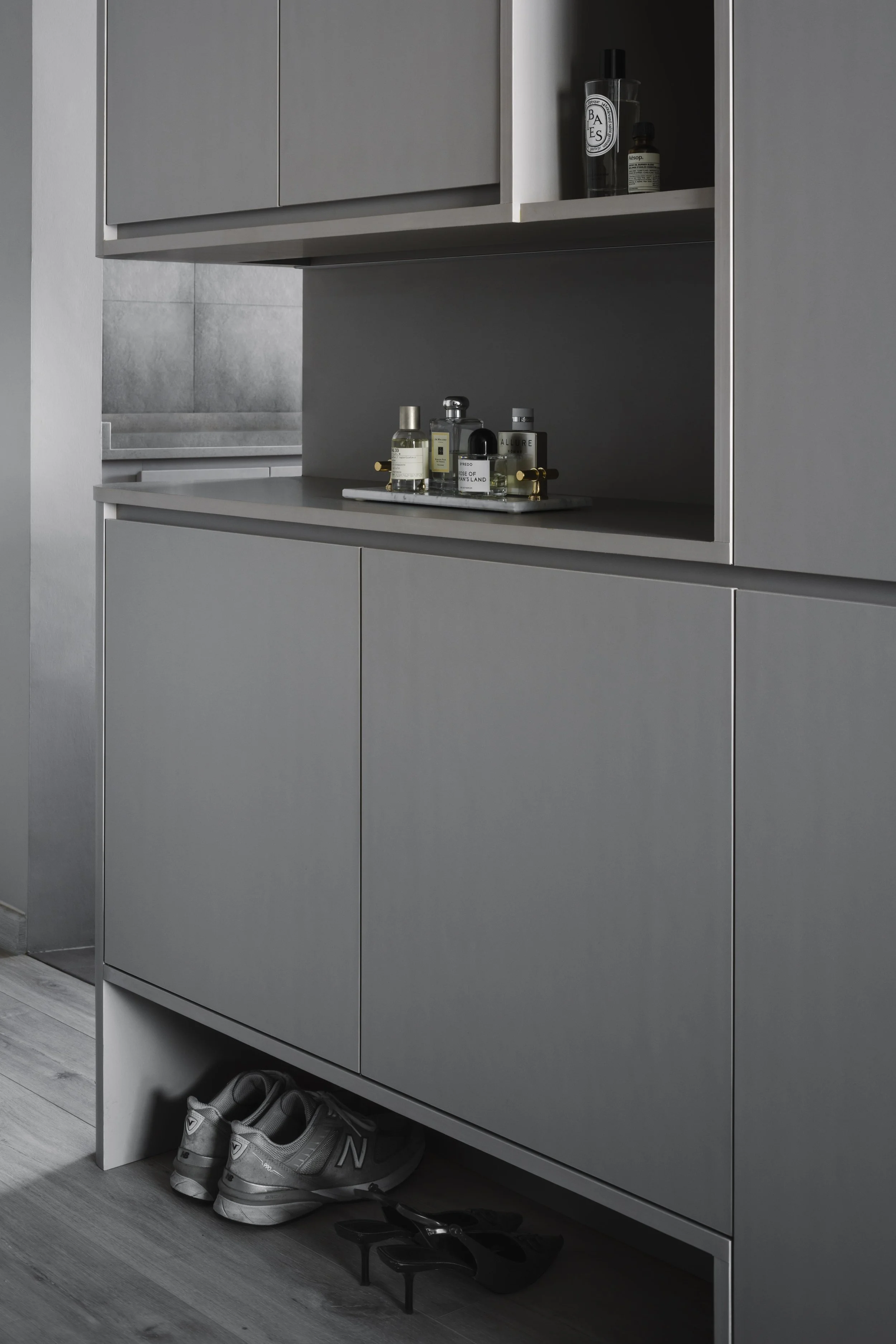 Matte grey built-in shoe cabinet with open display niche and concealed storage.