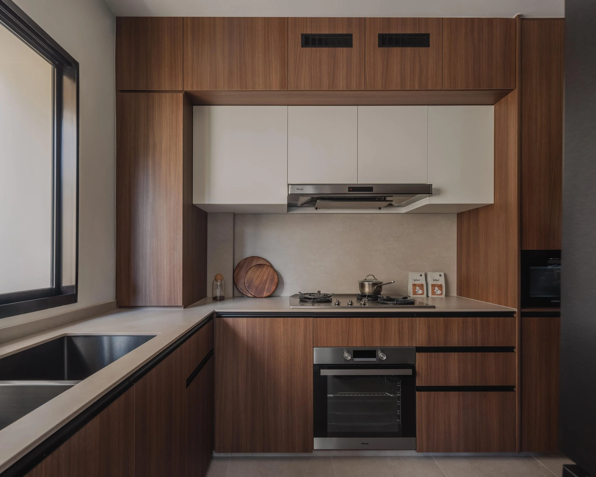 Modern wood-and-white kitchen in a Singapore home featuring clean cabinetry, built-in appliances and a minimalist countertop design.