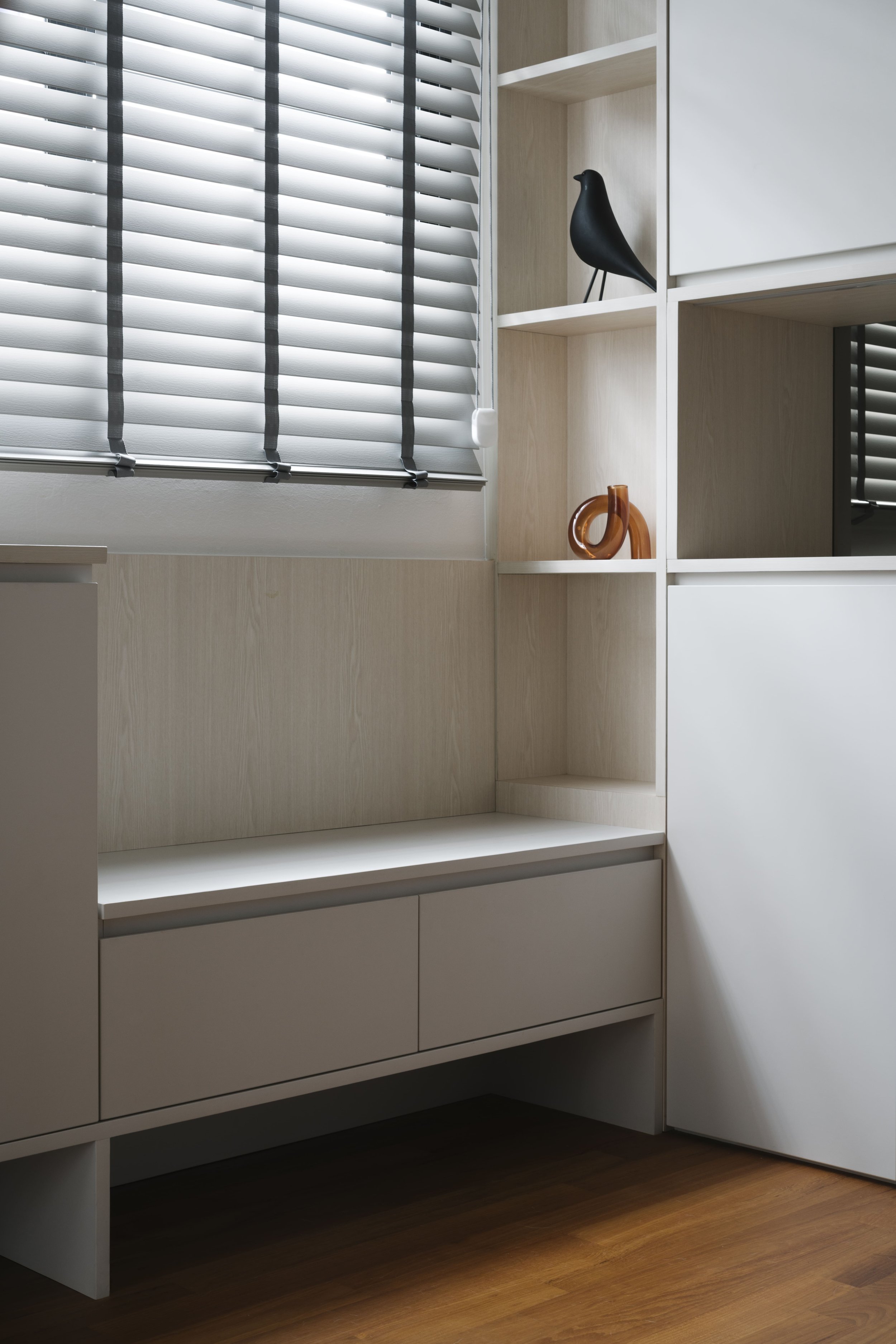 Custom window bench with built-in storage and shelving in a modern Singapore home.